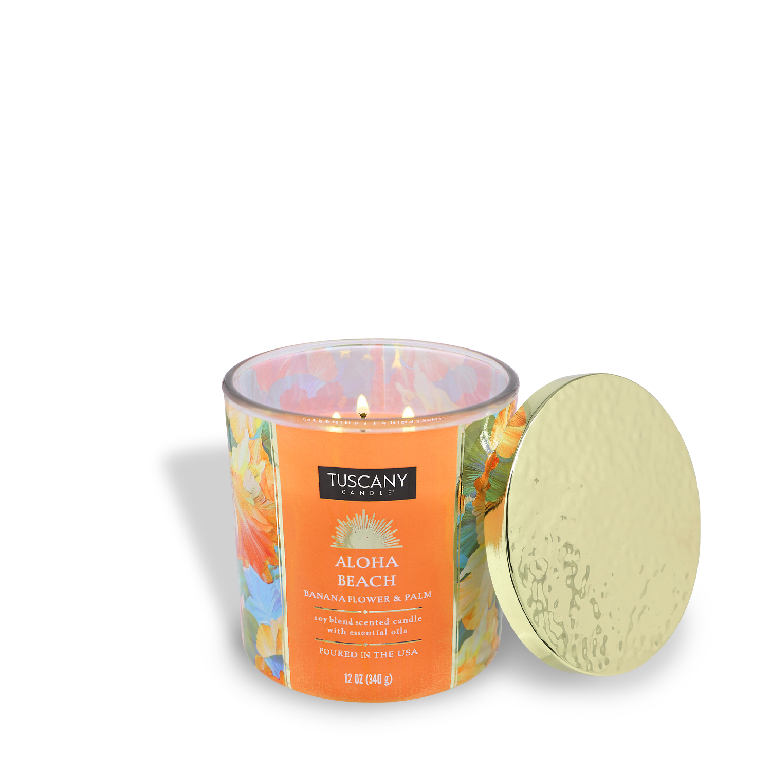 A lit Tuscany Candle® SEASONAL Aloha Beach: Banana Scented Summer Candle (12 oz) from the Island Glam Collection sits in a floral-patterned glass jar with a gold lid, filling the air with a vibrant, tropical summer scent.