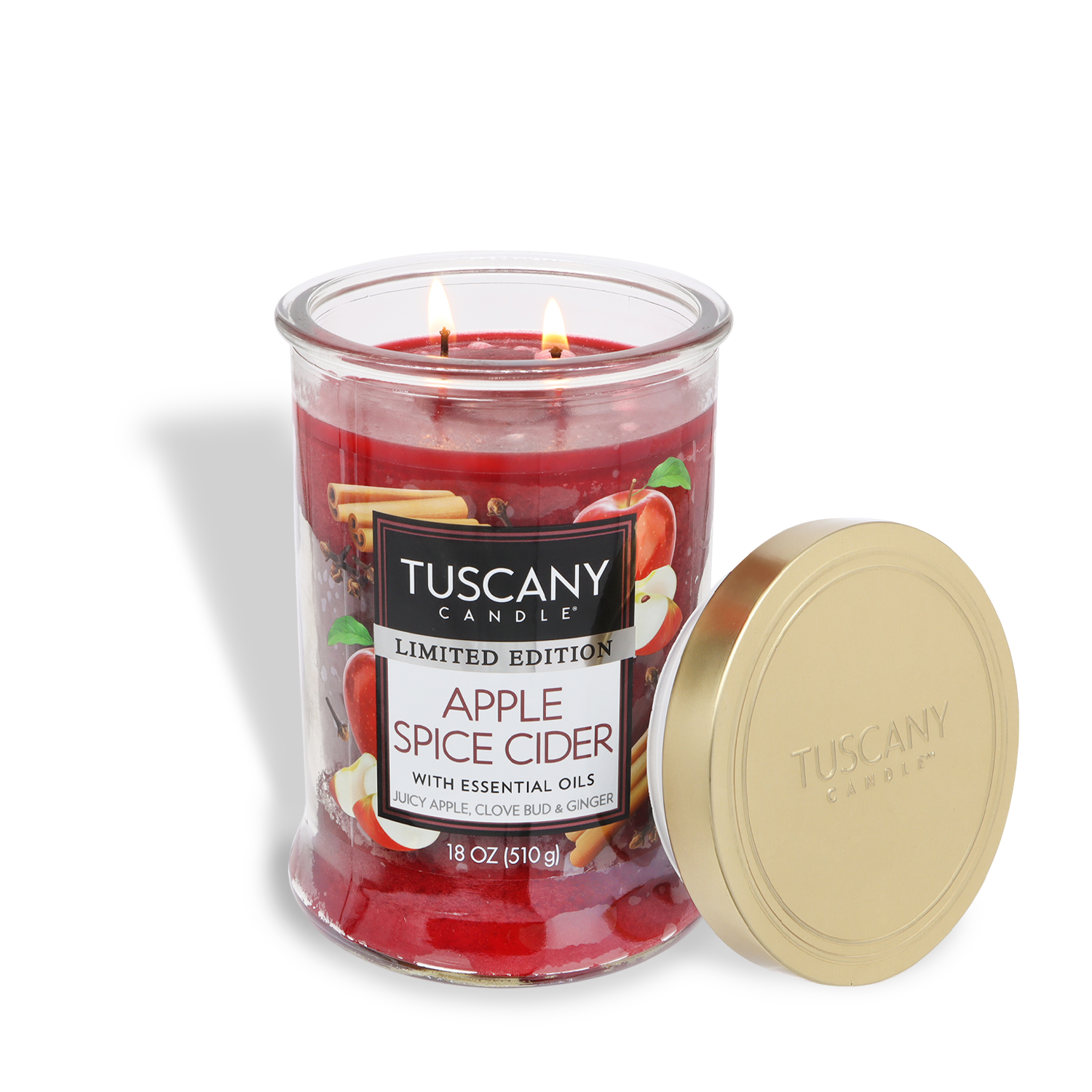 A lit Tuscany Candle® SEASONAL "Apple Spice Cider: Ginger & Clove Scented Fall Candle" (18 oz) in a glass jar, labeled and topped with a gold lid placed beside it.