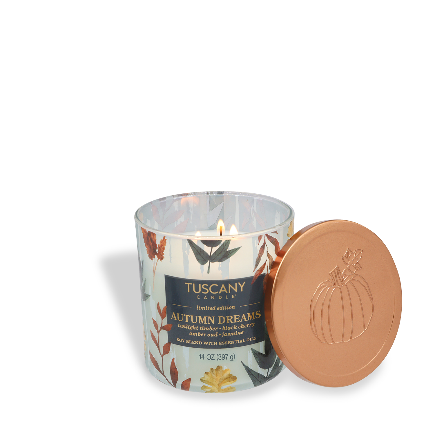 A lit Tuscany Candle® SEASONAL "Autumn Dreams: Black Cherry & Amber Oud" (14 oz) from the Simply Fall Collection sits by its copper pumpkin-design lid; the glass features a fall leaf pattern.