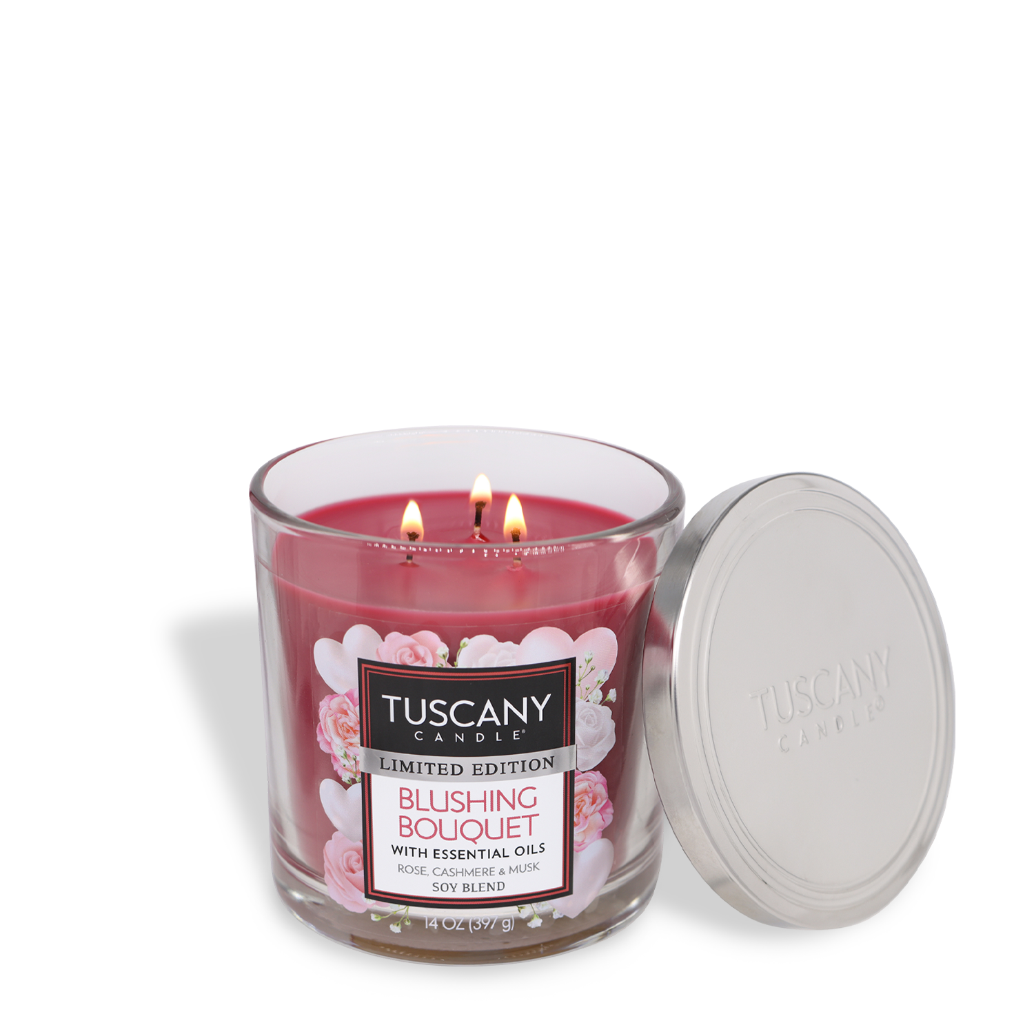 A Tuscany Candle® SEASONAL, labeled "Blushing Bouquet: Rose Scented Valentine’s Day Candle" (14 oz), featuring three lit wicks and an open silver lid, adds a perfect touch to Valentine's décor.