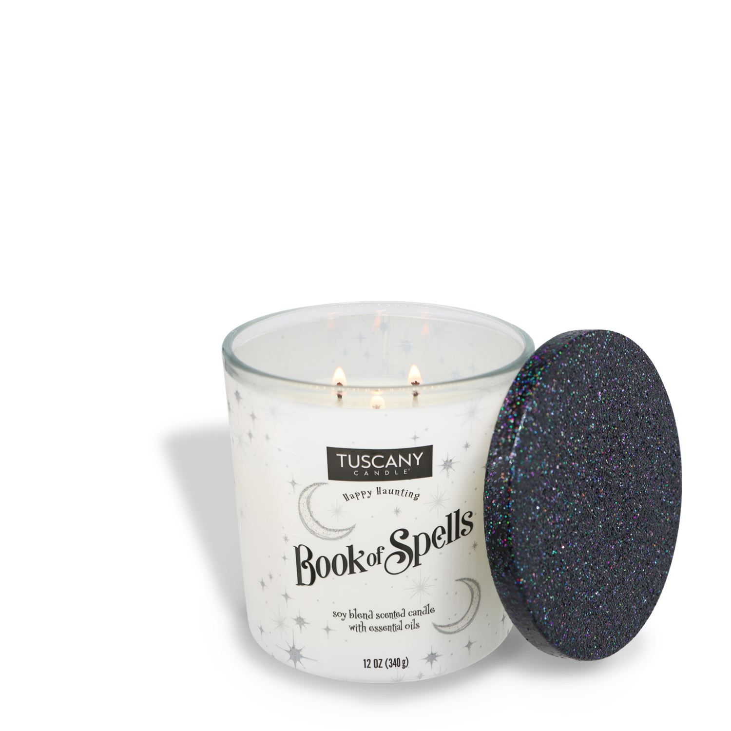 A Tuscany Candle® SEASONAL labeled "Book Of Spells Long-Lasting Scented Jar Candle (12 oz)" with essential oils and premium satin wax, in a glass container featuring stars and moons. The black lid with glitter is removed and placed beside the candle, revealing the enchanting fragrance notes within this elegant scented jar candle.