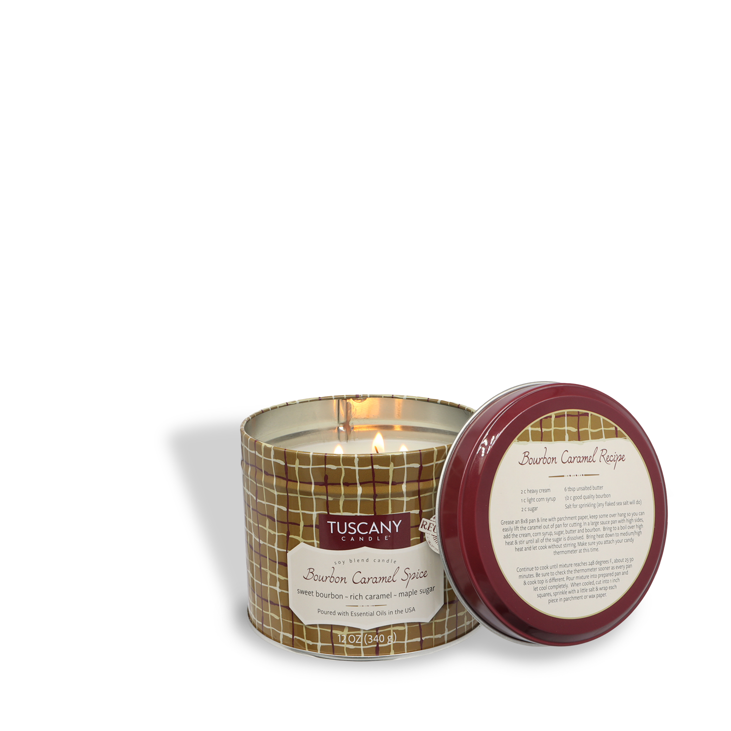 A lit Tuscany Candle® SEASONAL Bourbon Caramel Spice: Maple Sugar & Cinnamon scented 12 oz candle from the Bakery Tins Collection in a round tin with the matching lid placed beside it.