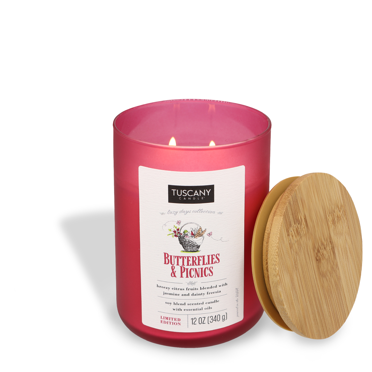 A Butterflies & Picnics scented candle with a pink label and a wooden lid off to the side.