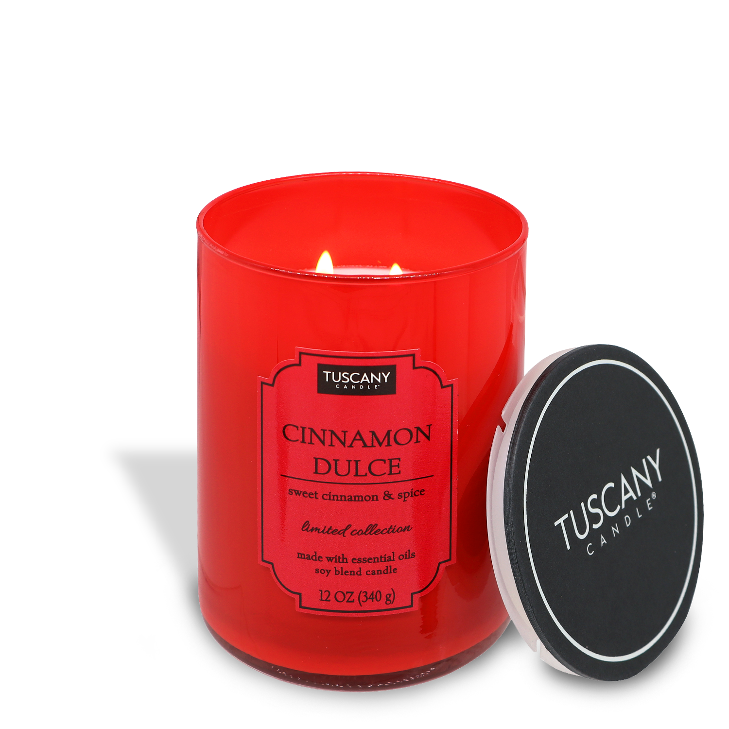 A lit red "Cinnamon Dulce (12 oz) – Colorsplash Collection" candle in a glass jar, with its lid off to the side, isolated on a white background.