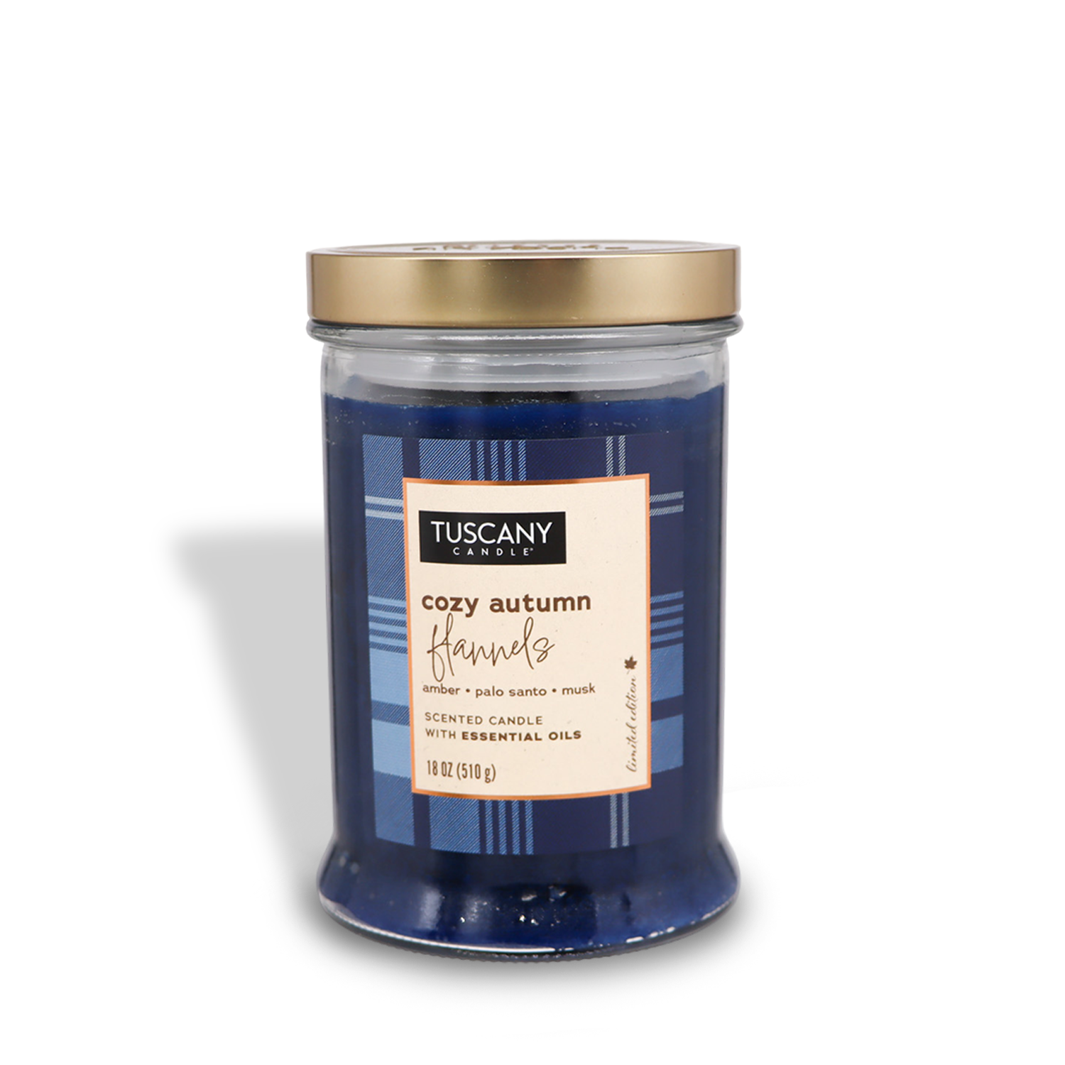 A blue candle in a glass jar with a gold lid labeled “Tuscany Candle® SEASONAL, Cozy Autumn Flannels Long-Lasting Scented Jar Candle (18 oz) — Autumn Flannels Collection.” Scented with amber, palo santo, and musk, it weighs 18 oz (510 g).