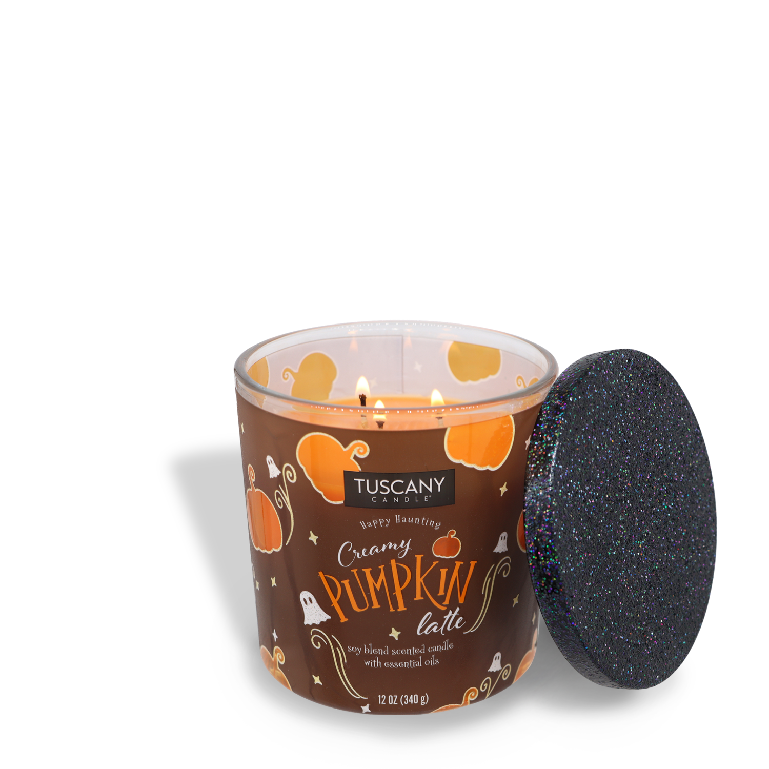 A lit Tuscany Candle® SEASONAL brand "Creamy Pumpkin Latte Long-Lasting Scented Jar Candle (12 oz)" in a brown container with pumpkins and a black glittery lid resting beside it, crafted from premium satin wax.