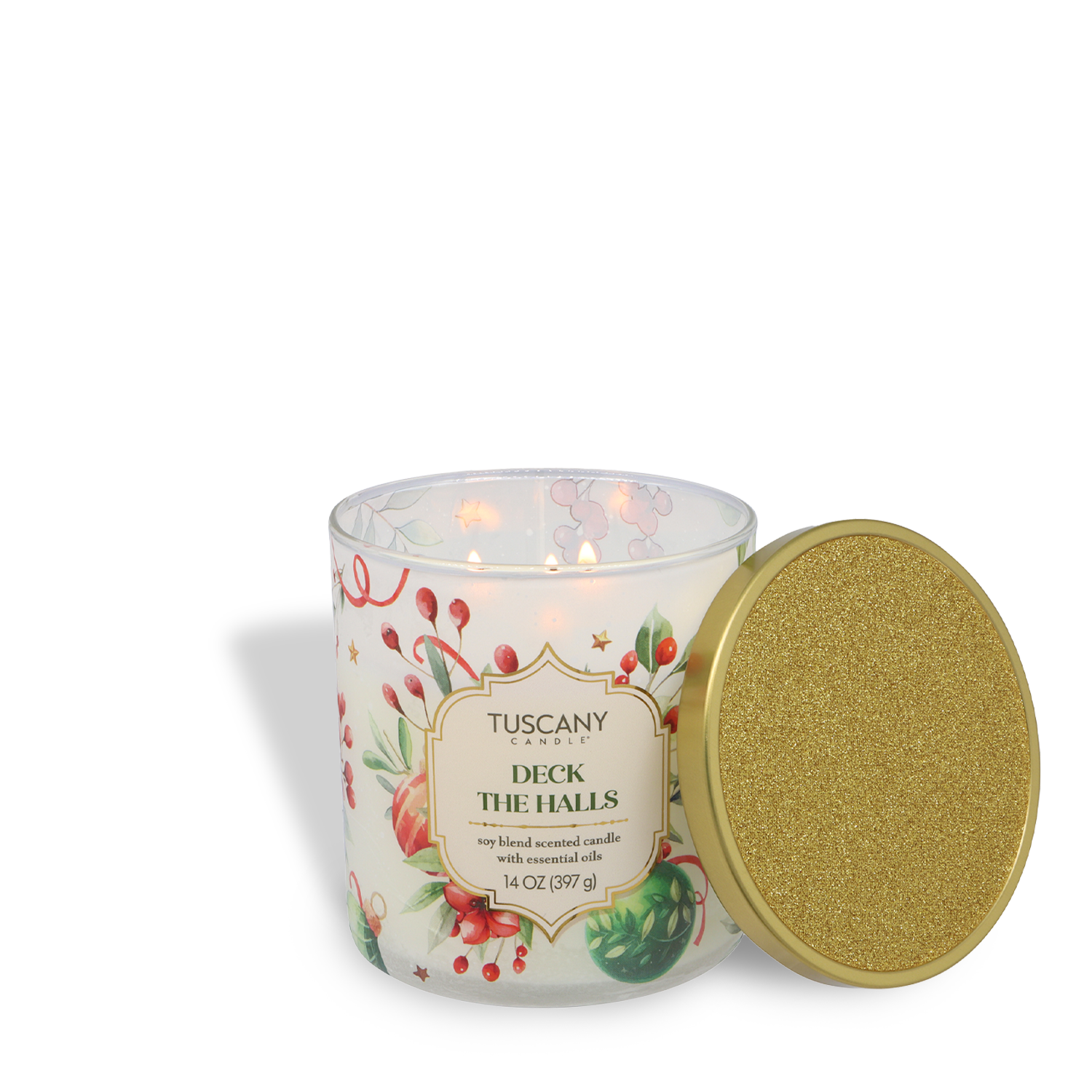 A lit Tuscany Candle® SEASONAL "Deck The Halls: Evergreen & Clementine Scented Holiday Candle" (14 oz) from the Traditions Collection sits beside a gold glittery lid, its jar adorned with festive holiday floral decorations.