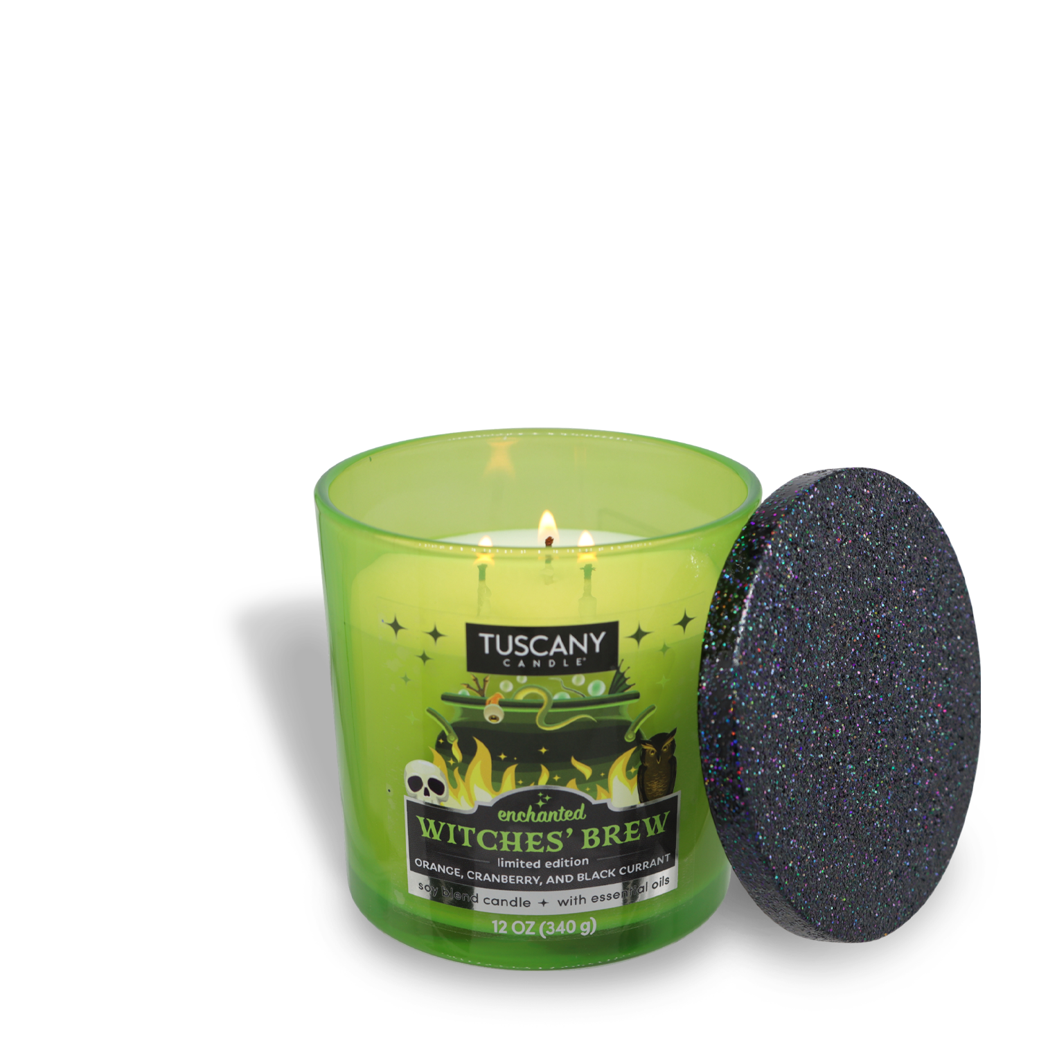 A lit green candle with a black glittery lid next to it. The label reads "Tuscany Candle® SEASONAL: Enchanted Witches Brew Long-Lasting Scented Jar Candle (12 oz)" and lists the scent as orange, cranberry, and black currant. This premium satin wax candle in a jar boasts 50 hours burn time for an enchanting aromatic experience.