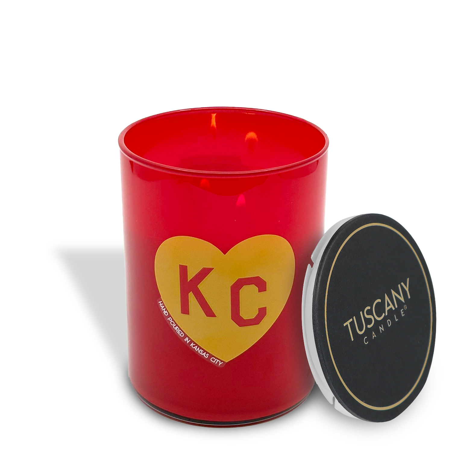 The Fall Festival Scented Red KC Heart Candle (13 oz) by Tuscany Candle x Charlie Hustle features a red jar with a yellow "KC" heart and a black lid with the "TUSCANY CANDLE" logo, celebrating their collaboration.