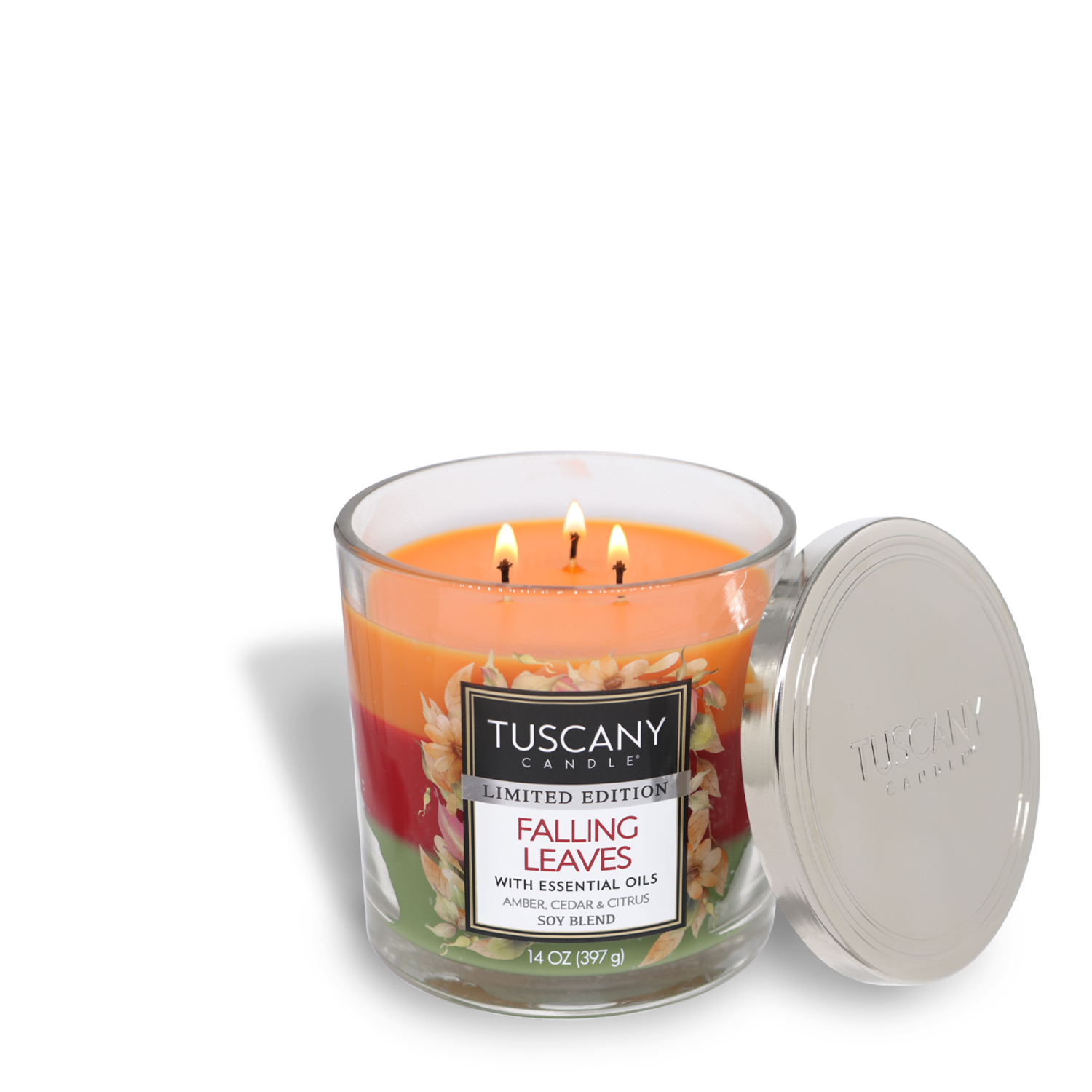 A lit Tuscany Candle® SEASONAL Falling Leaves Long-Lasting Scented Jar Candle (14 oz), crafted with premium satin wax, emits an amber scent and a citrus blend. Featuring three wicks and an open silver lid, this scented jar candle stands elegantly on a white background.