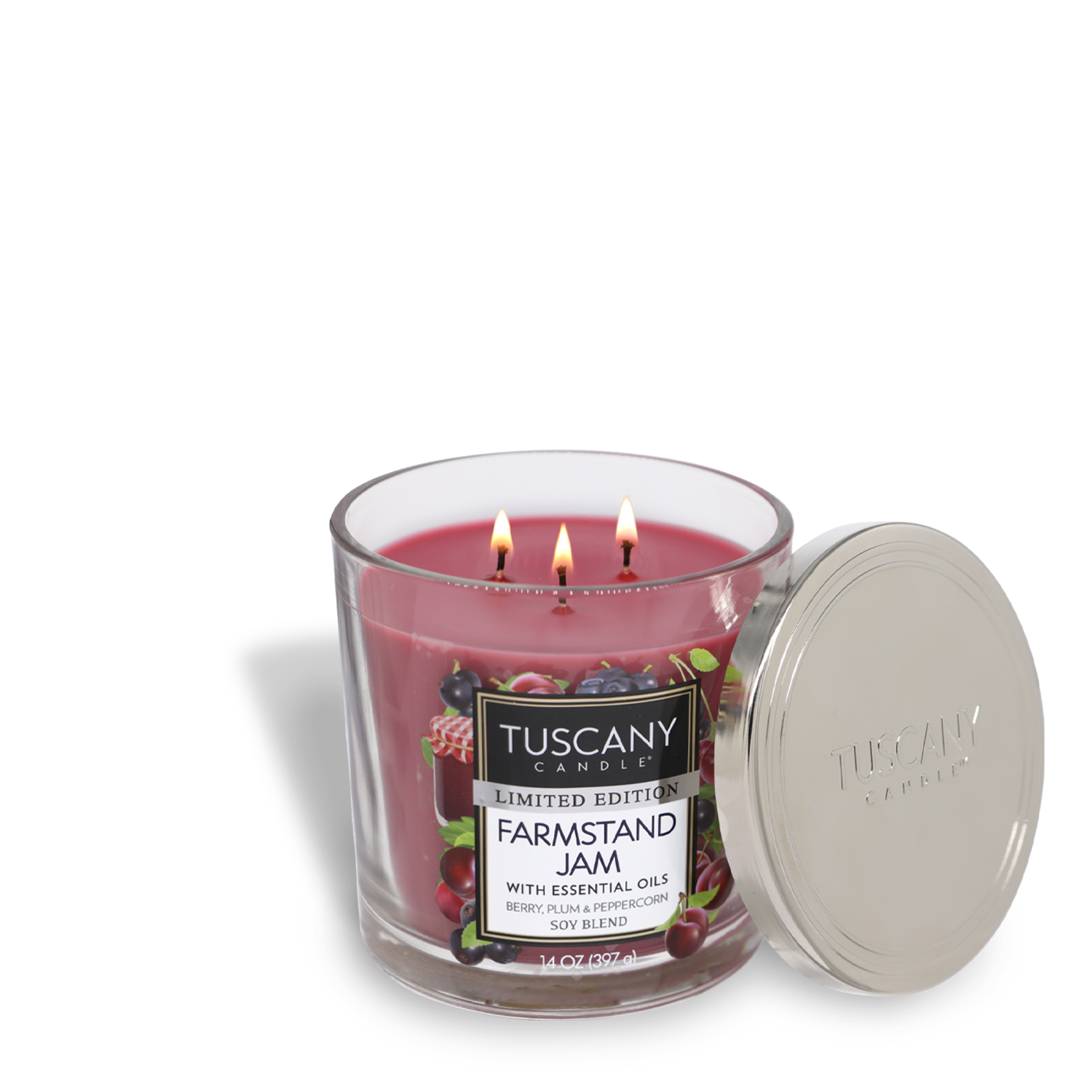 A Tuscany Candle® SEASONAL Farmstand Jam Long-Lasting Scented Jar Candle (14 oz) in a glass jar labeled "Farmstand Jam" with three lit wicks, positioned next to its lid. The scented jar candle is a berry color and is part of the limited edition collection.