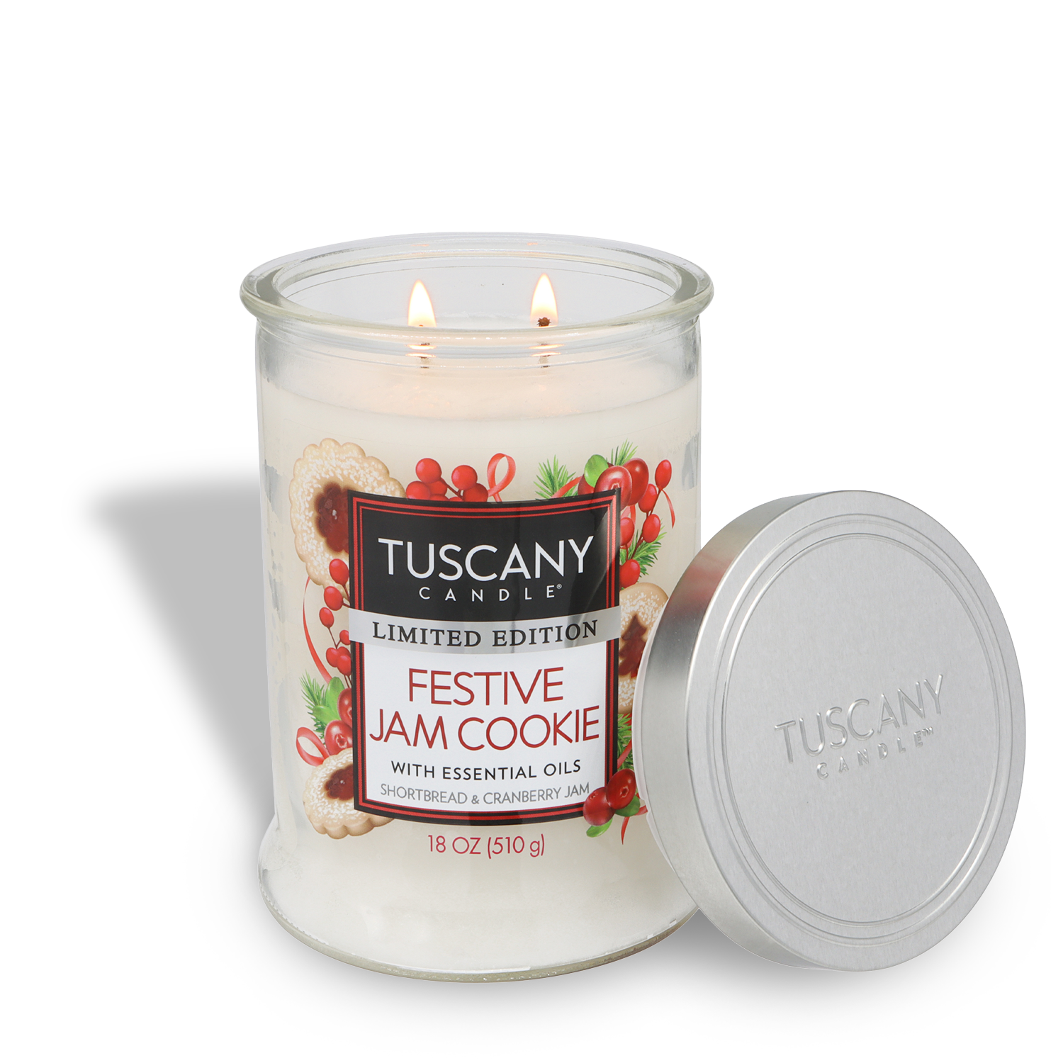 An open Tuscany Candle® SEASONAL "Festive Jam Cookie: Shortbread & Cranberry Scented Holiday Candle" (18 oz) with two lit wicks and the lid beside it. The label shows cookies and cranberries.