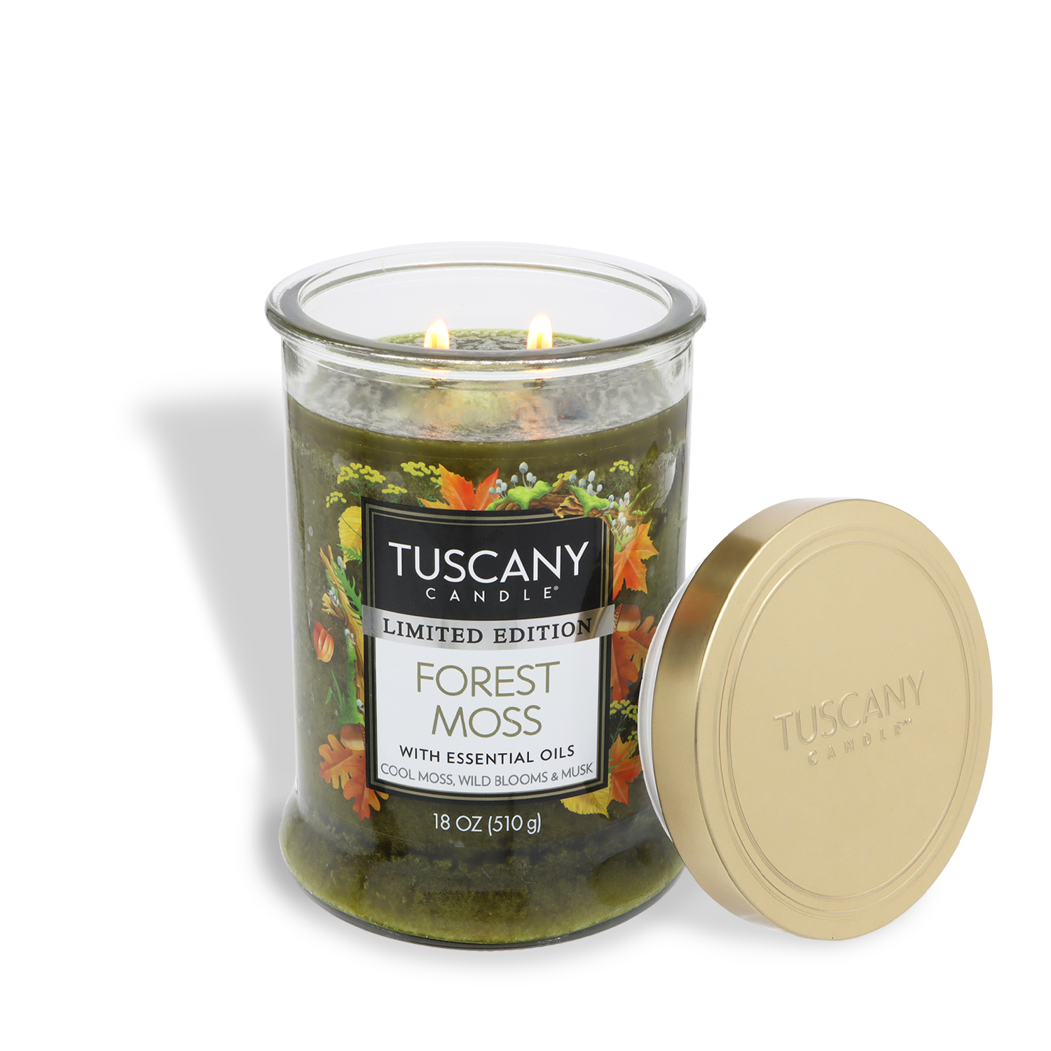 An 18 oz Tuscany Candle® SEASONAL Forest Moss: Eucalyptus & Musk scented fall candle with green wax, two lit wicks, and a gold lid placed beside its glass jar.