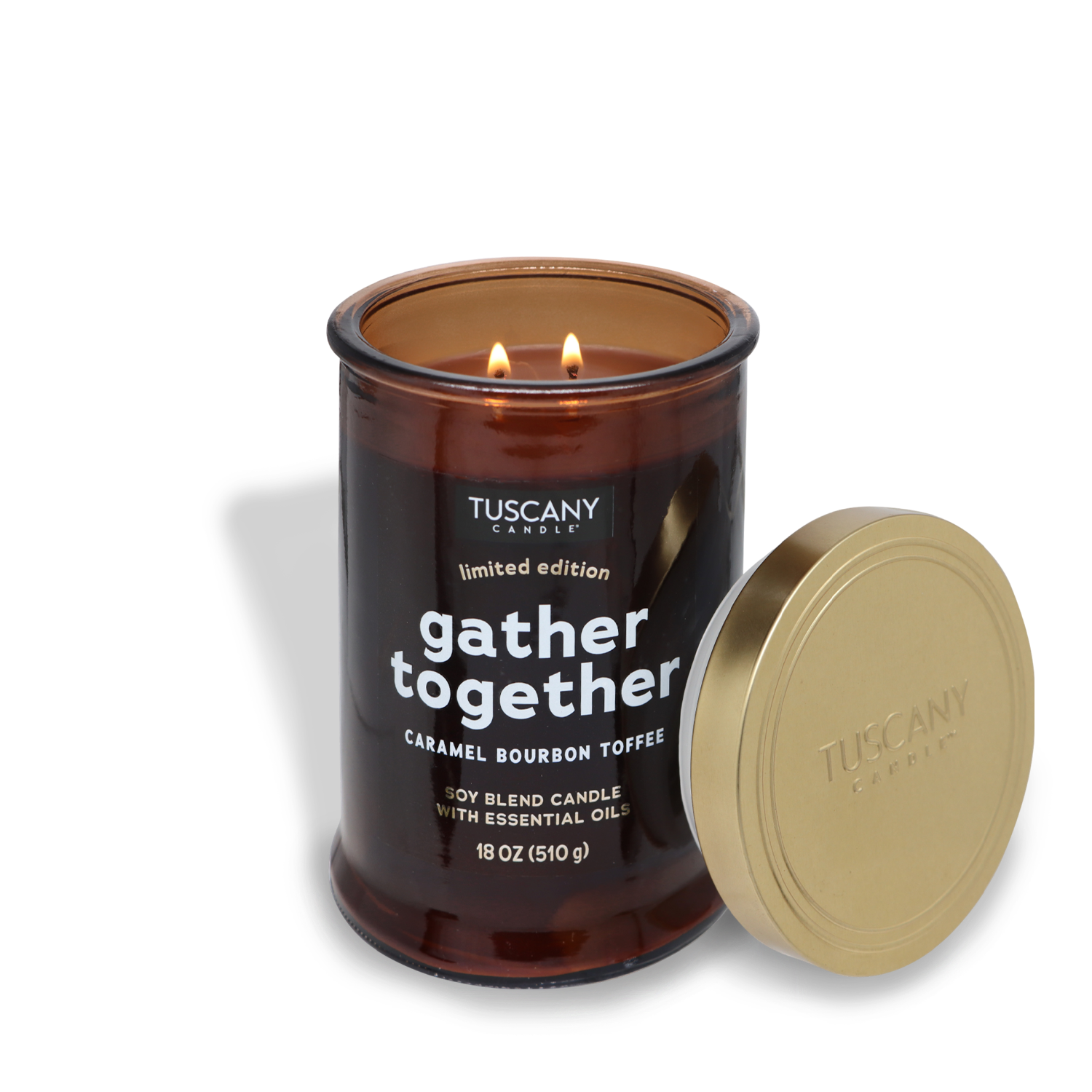 A lit Tuscany Candle® SEASONAL "Gather Together Long-Lasting Scented Jar Candle (18 oz)" from the Gather Together Collection in a brown glass jar sits with the lid beside it. The luxurious fragrance of caramel infused with aged bourbon fills the room. This candle boasts a delightful caramel bourbon toffee scent perfect for cozy evenings.