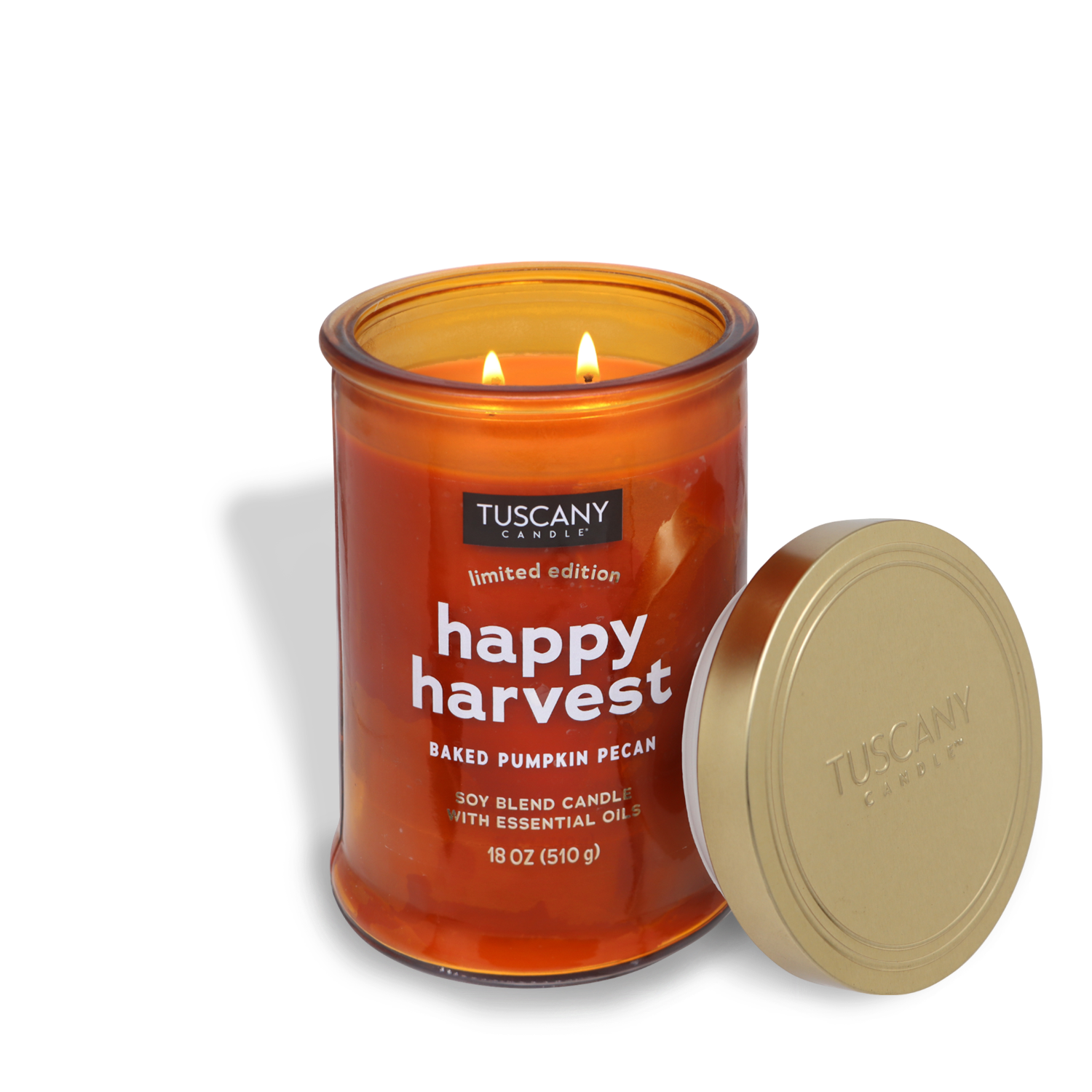 A Happy Harvest Long-Lasting Scented Jar Candle (18 oz) from the Tuscany Candle® SEASONAL Gather Together Collection, featuring two lit flames and a gold lid resting beside its orange glass jar, fills the air with a delightful autumn scent.