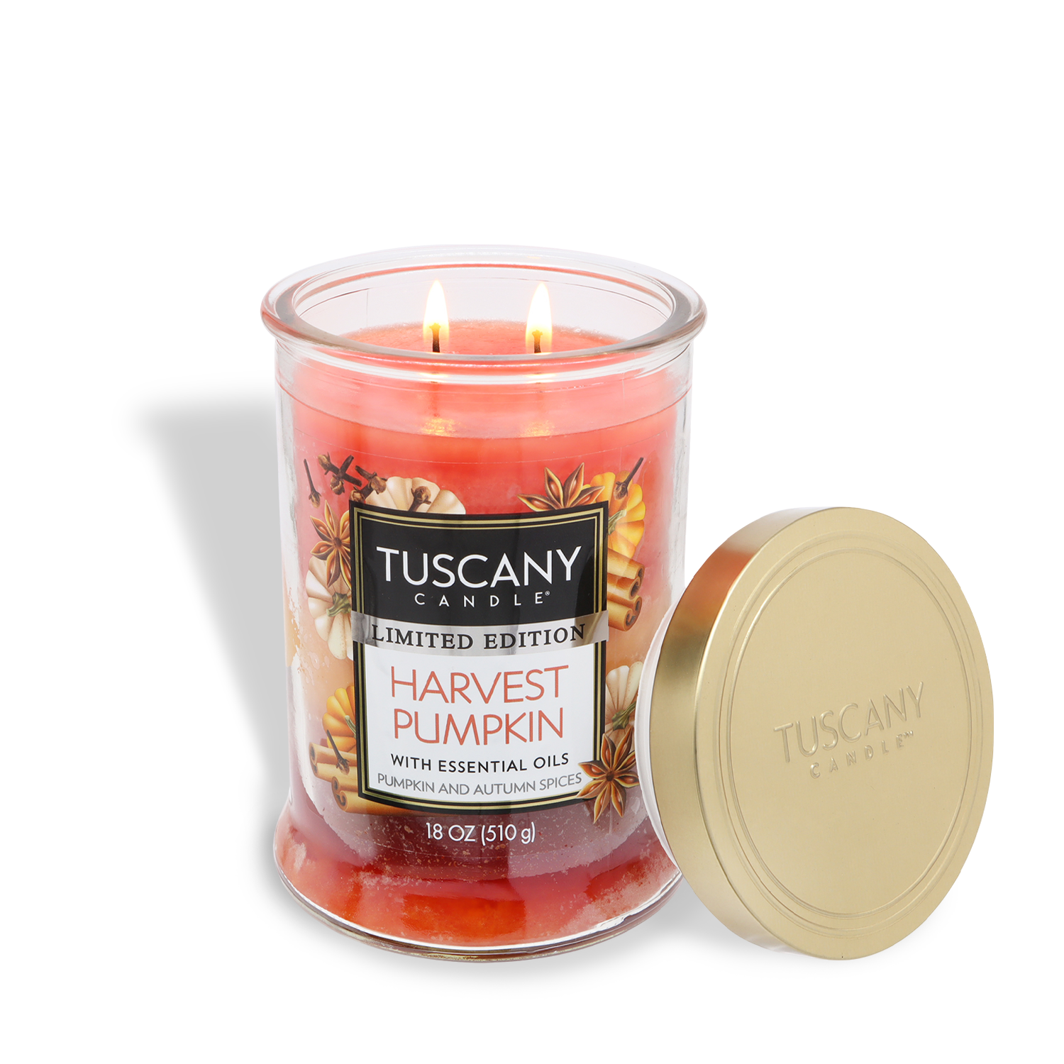 A lit Tuscany Candle® SEASONAL jar labeled "Harvest Pumpkin: Nutmeg & Clove Scented Fall Candle (18 oz)" sits with its gold lid nearby. The orange candle's label highlights pumpkin and autumn spice notes.