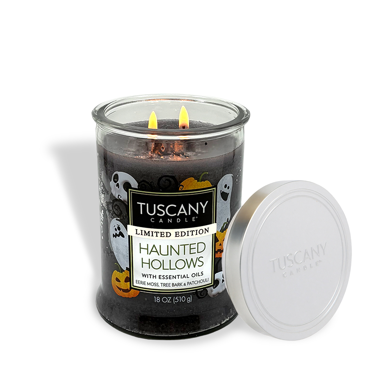 The Tuscany Candle® SEASONAL "Haunted Hollows: Eerie Moss & Tree Bark" 18 oz jar candle features two lit wicks, Halloween-themed decor, a silver lid, and a soy blend that brings spooky charm to your space.