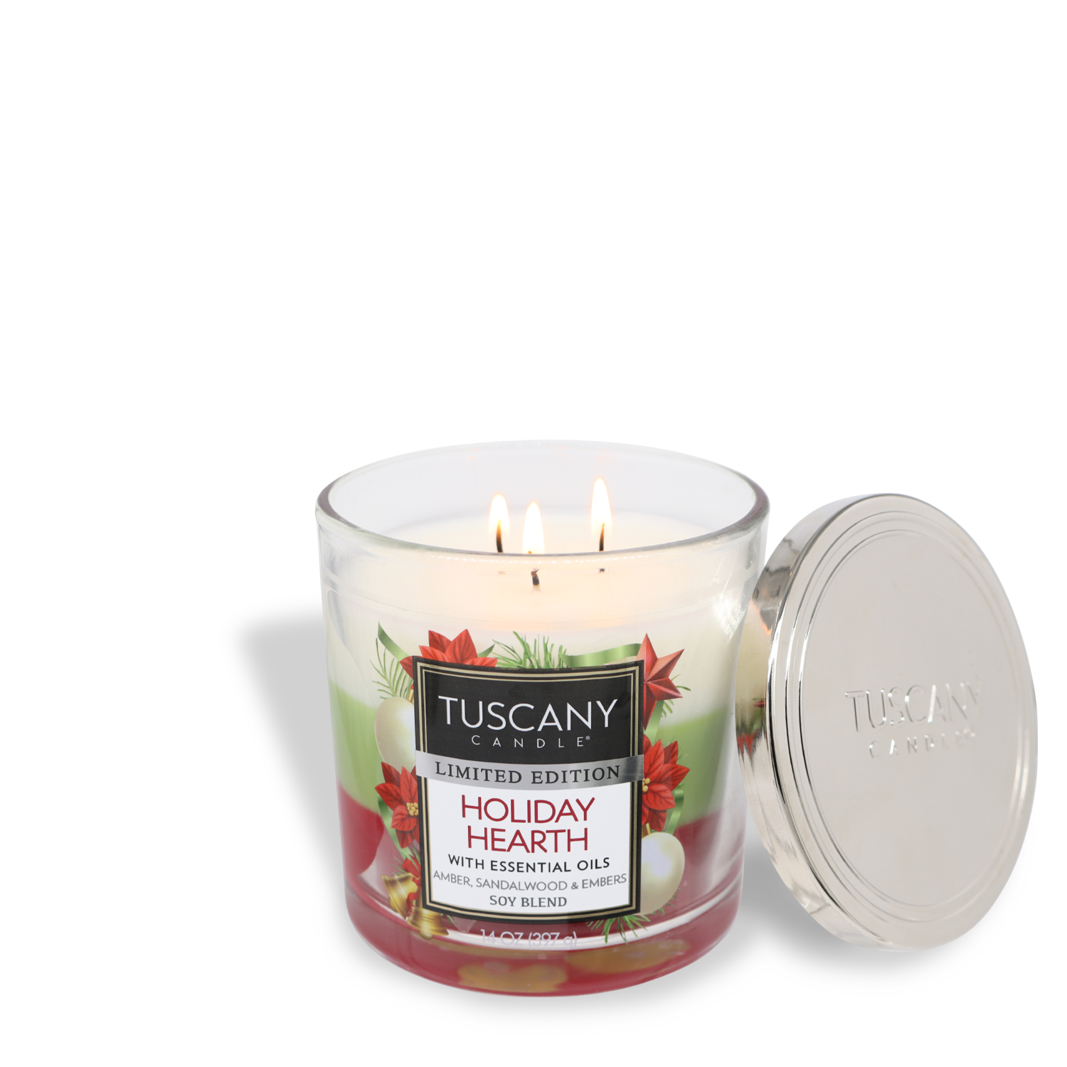 A Tuscany Candle® SEASONAL product, the "Holiday Hearth Long-Lasting Scented Jar Candle (14 oz)" with essential oils, featuring three lit wicks and a metallic lid resting beside it.