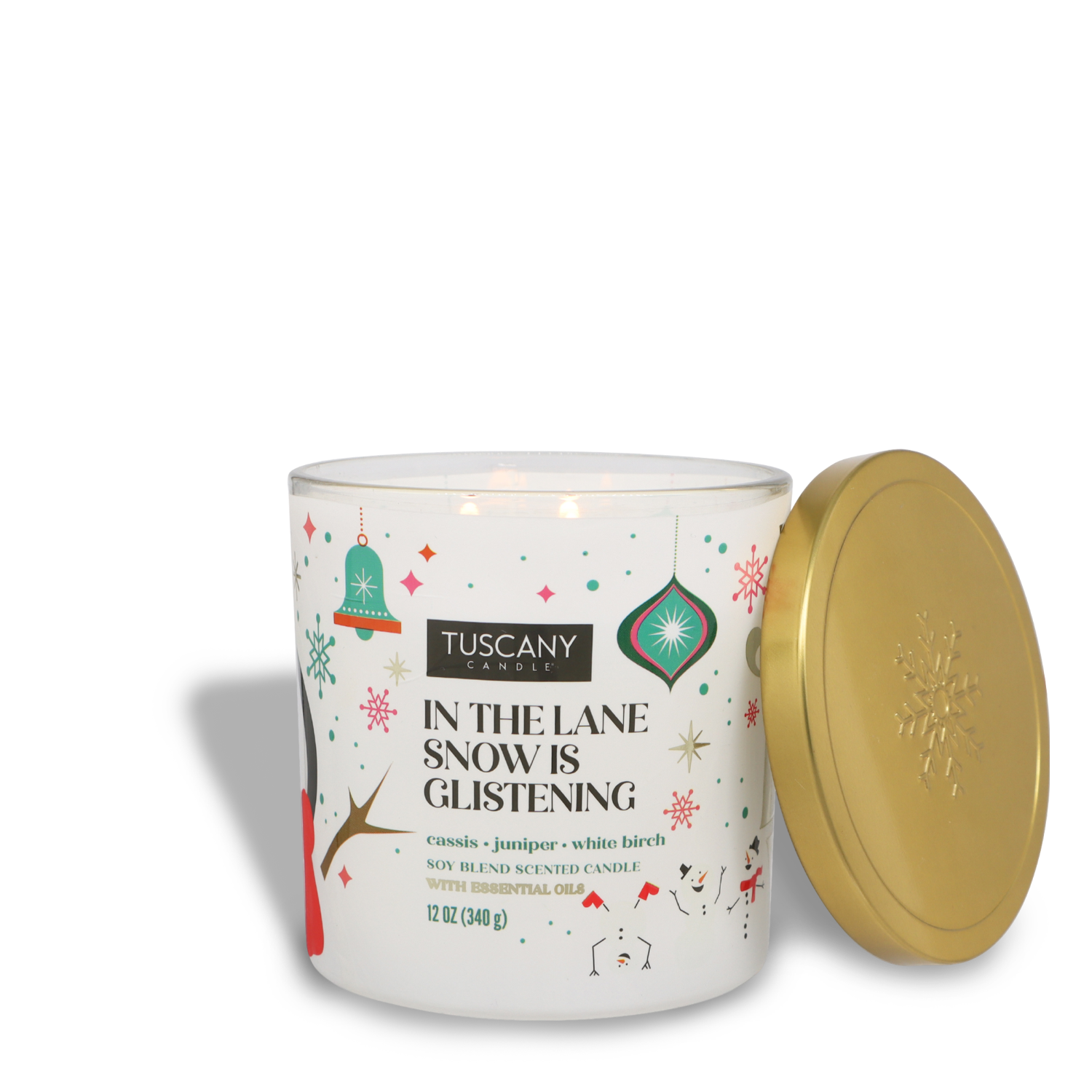 A lit Tuscany Candle® SEASONAL "In The Lane Snow is Glistening" scented jar candle (12 oz) displays its holiday-themed illustrations on the label, while the lid rests beside it.