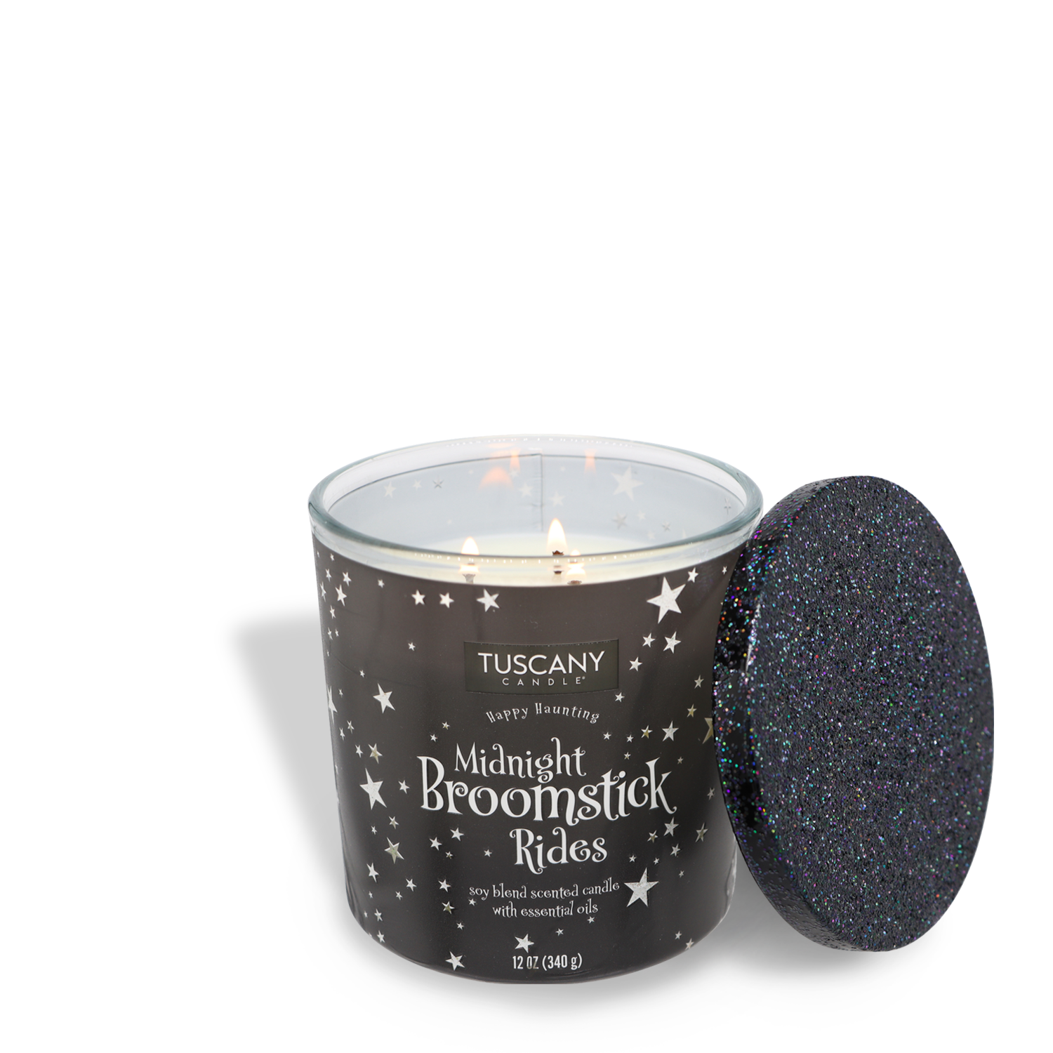 A lit Tuscany Candle® SEASONAL "Midnight Broomstick Rides Long-Lasting Scented Jar Candle (12 oz)" in a black and white star-patterned jar with a matching glittery black lid beside it, featuring premium satin wax and three wicks for an enhanced glow.