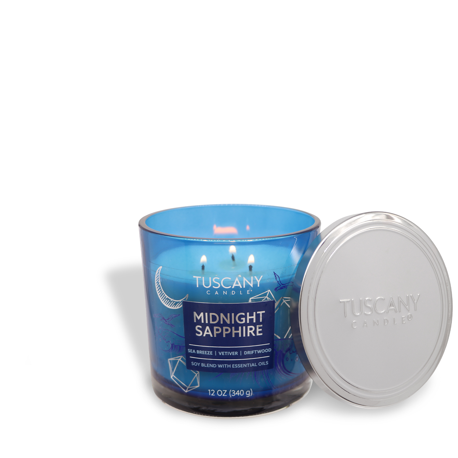 The lit blue jar candle, "Midnight Sapphire," from Tuscany Candle® EVD's Painters' Palette Collection, features sea breeze, vetiver, and driftwood scents. The lid is placed beside it. (12 oz).