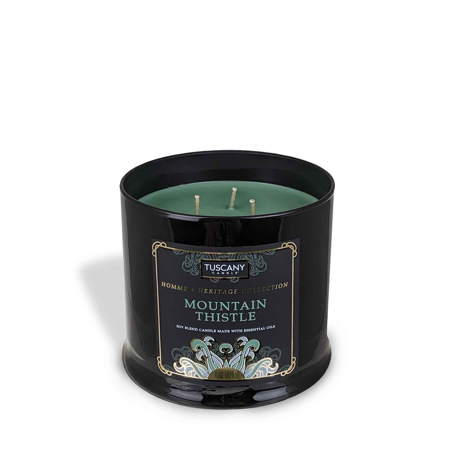 A Mountain Thistle Scented Jar Candle (15 oz) from the Homme + Heritage Collection by Tuscany Candle in a black tin with a green lid.