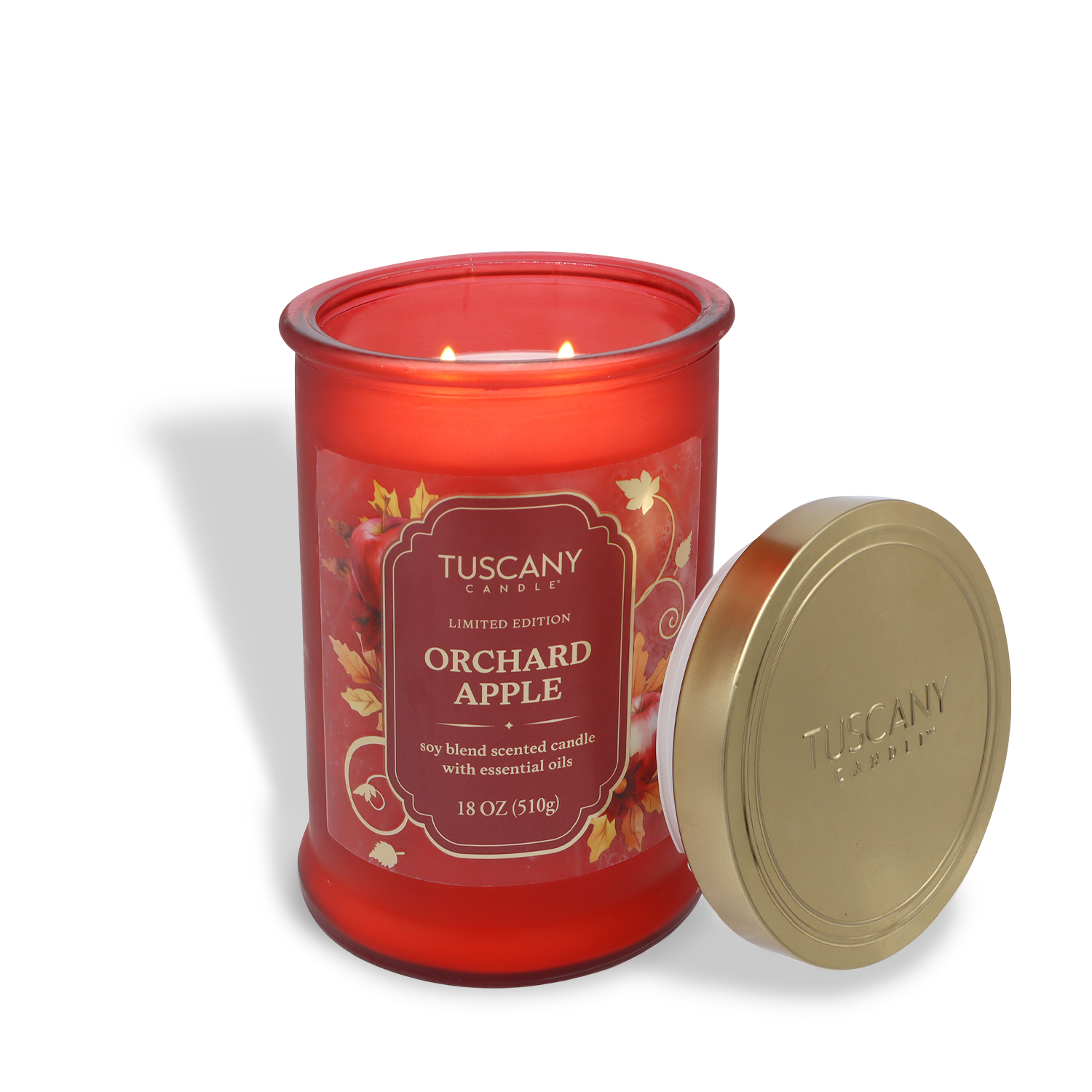 A lit Tuscany Candle® SEASONAL "Orchard Apple: Sweet Apple & Clove Scented Fall Candle" (18 oz) with a gold lid sits on a white background.
