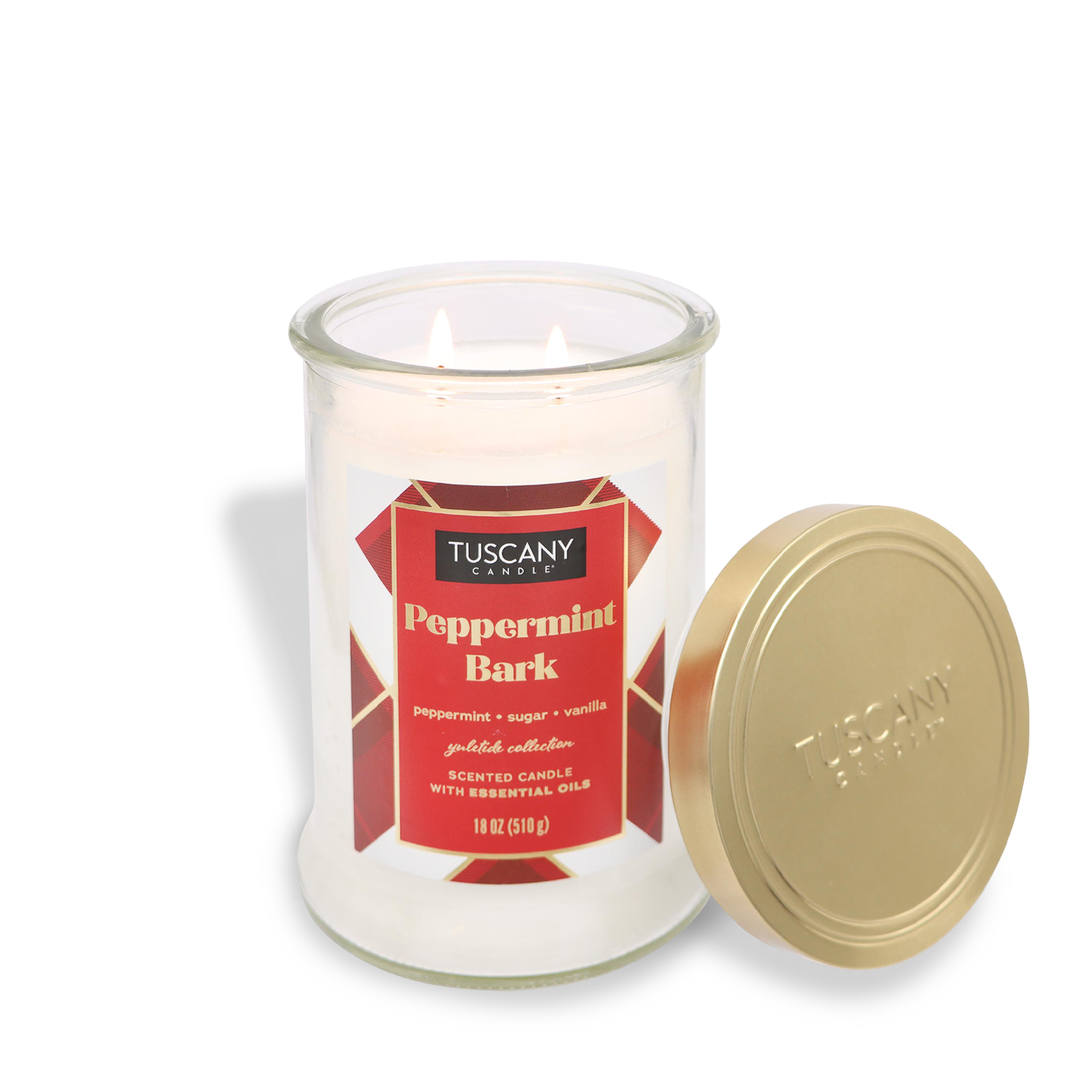 A lit Peppermint Bark Scented Jar Candle (18 oz) from the Winter Flannels Collection by Tuscany Candle® SEASONAL in a glass jar, featuring a gold lid placed beside it.