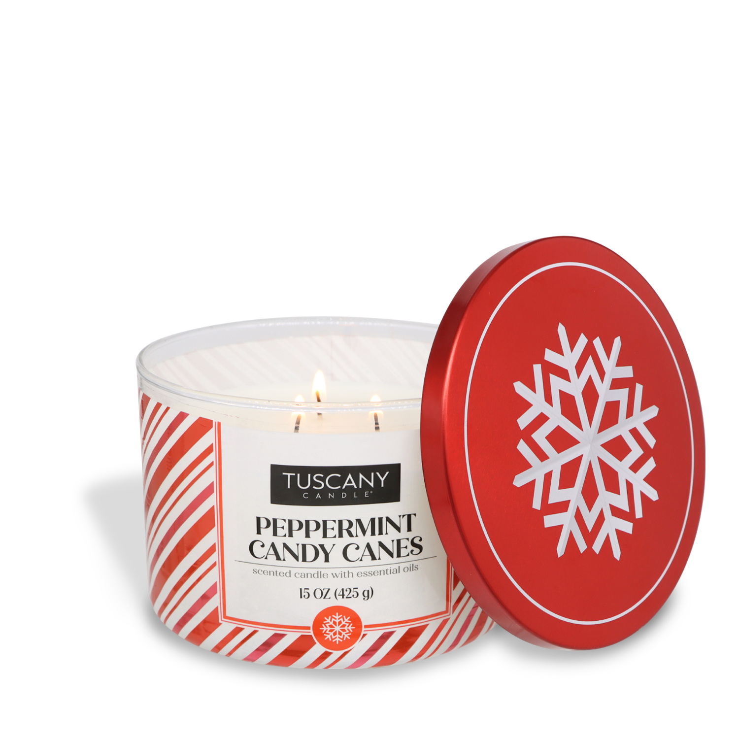 A lit Tuscany Candle SEASONAL labeled "Peppermint Candy Canes Scented Jar Candle (15 oz)" in a red and white striped container with a red lid featuring a white snowflake design.