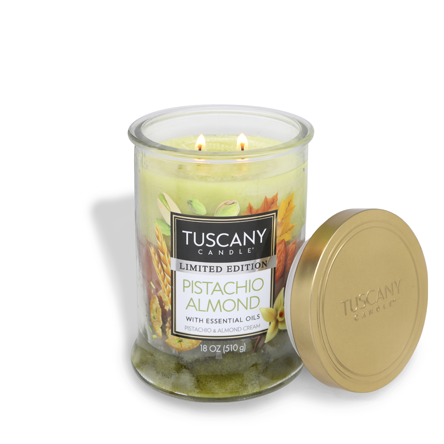 A Tuscany Candle® SEASONAL from the Tuscany Classic Collection labeled "Pistachio Almond Long-Lasting Scented Jar Candle (18 oz)" with essential oils. The lid is placed next to the candle, and the scented candle features two wicks.