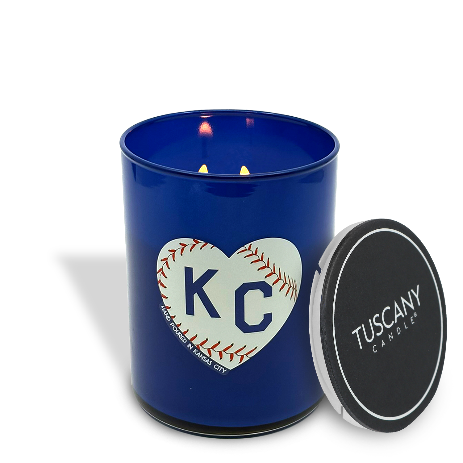 The Play Ball! Scented Baseball KC Heart Candle (13 oz) by Tuscany Candle x Charlie Hustle features a heart-shaped baseball and “KC” on a blue glass jar, plus a black Tuscany Candle lid—perfect for Kansas City fans.