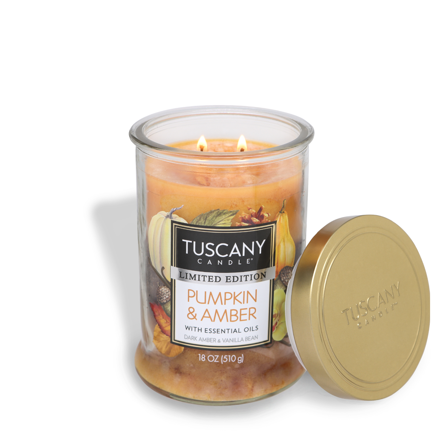 A lit Tuscany Candle® SEASONAL Pumpkin & Amber Long-Lasting Scented Jar Candle (18 oz) in a glass jar with a lid beside it. The label reads "Pumpkin & Amber with essential oils, Dark Amber & Vanilla Bean, Limited Edition, 18 oz/510 g." This delightful scented candle fills the room with rich fragrance notes that create a warm and inviting atmosphere.