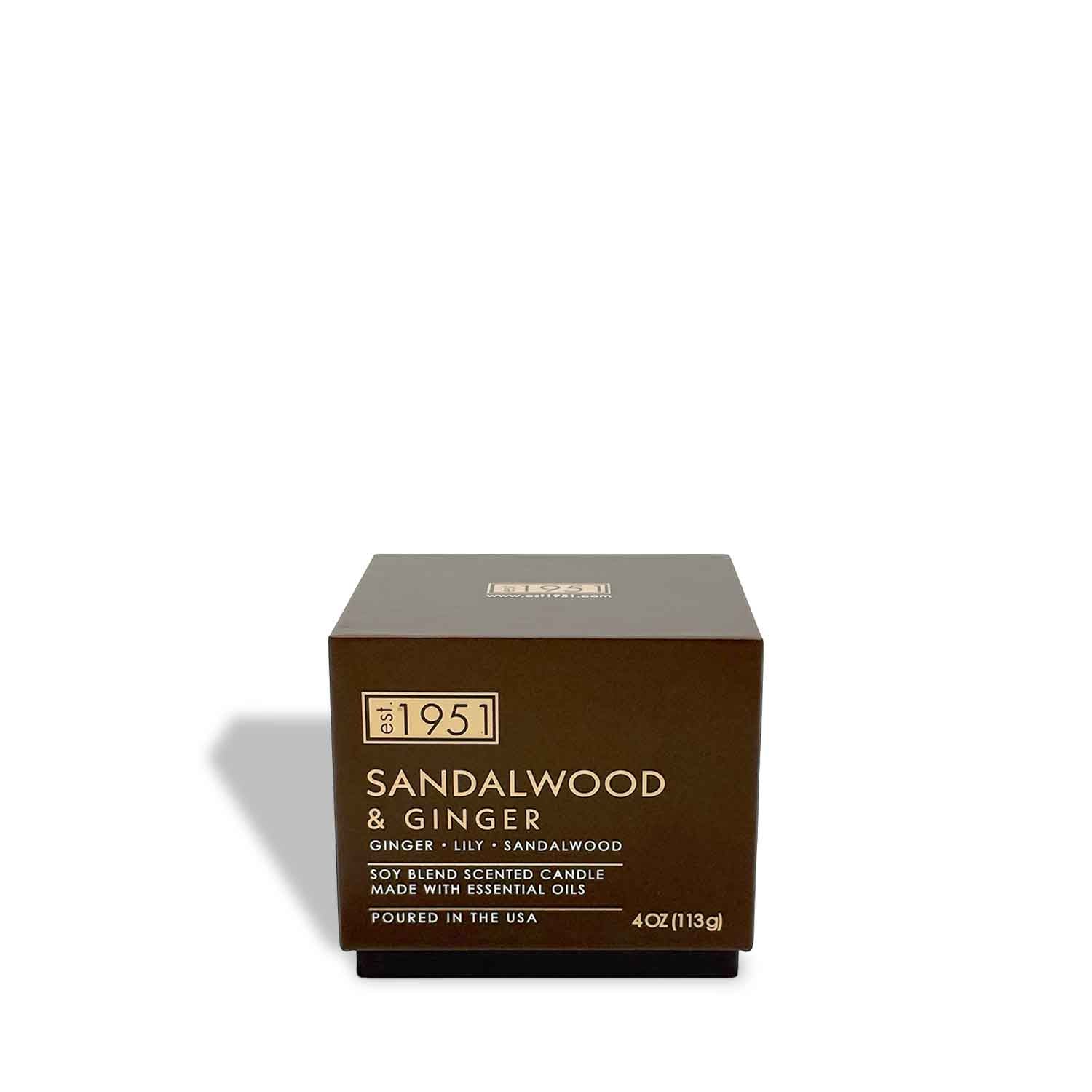A 4oz est.1951 Sandalwood & Ginger candle with essential oils and a soothing ginger scent, made in the USA, is shown in its brown box on a white background.