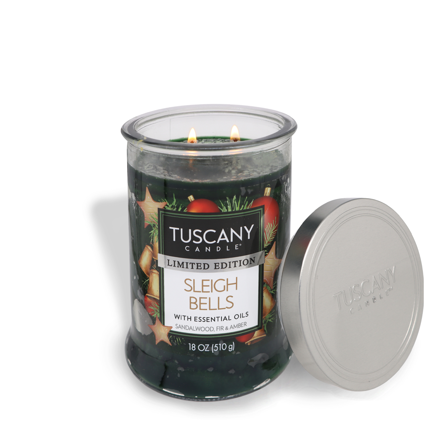 A glass jar of the Tuscany Candle® SEASONAL "Sleigh Bells Long-Lasting Scented Jar Candle (18 oz)," adorned with holiday-themed graphics, sits with the lid off and reveals its two wicks.