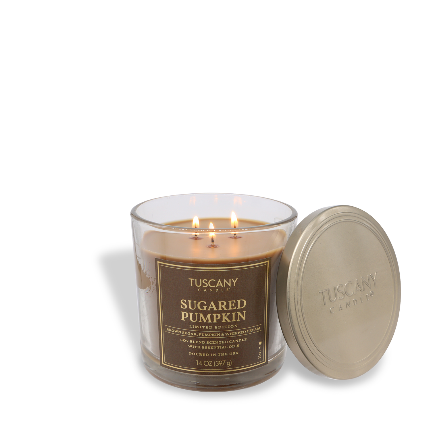 A Tuscany Candle® SEASONAL 14 oz glass jar candle labeled "Sugared Pumpkin: Smoked Cinnamon & Brown Sugar" sits lit, with its lid beside it.