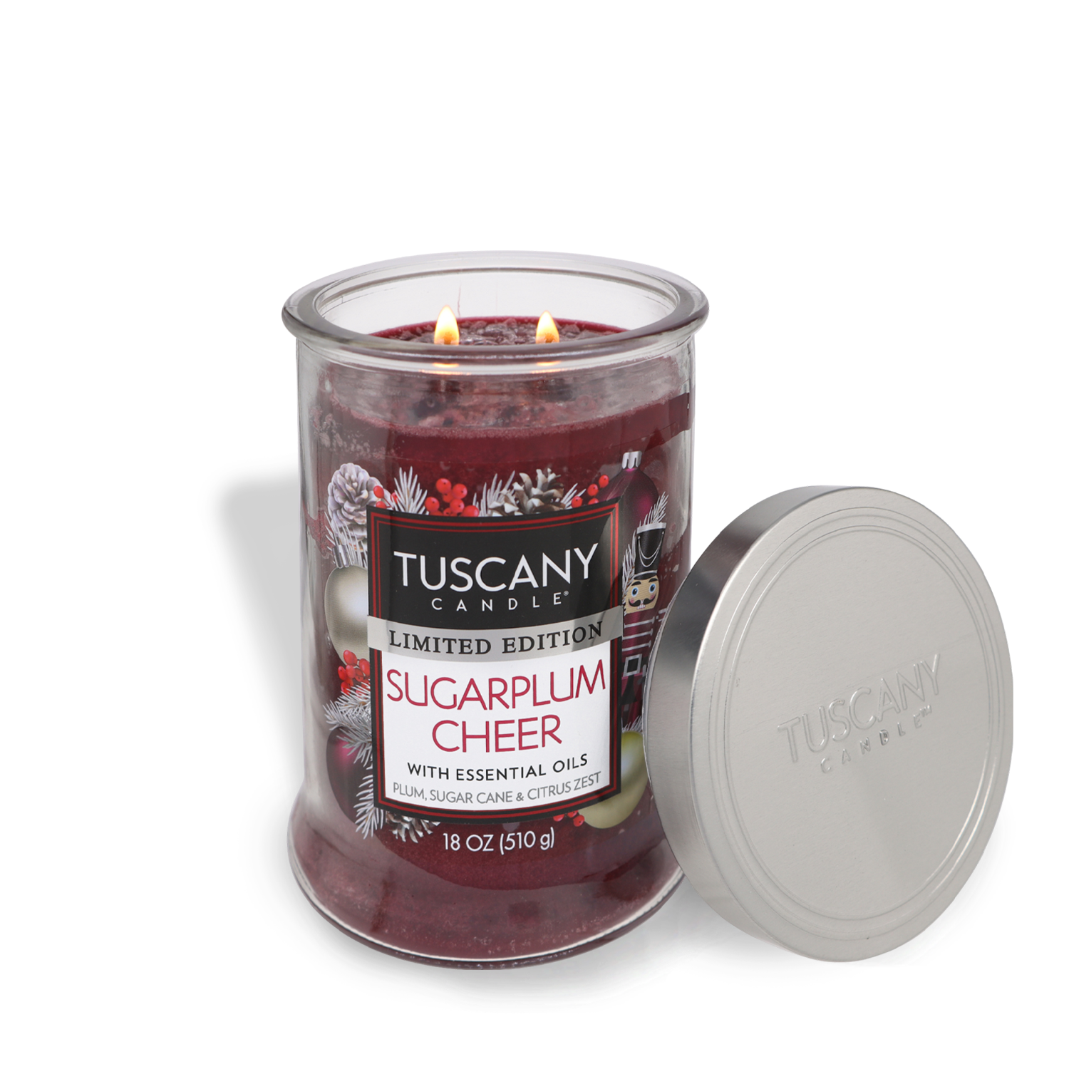 A lit Sugarplum Cheer Long-Lasting Scented Jar Candle (18 oz) from Tuscany Candle® SEASONAL in a glass jar with a silver lid beside it. The candle is labeled "Limited Edition Sugarplum Cheer" and described as having essential oils, plum, sugar cane, and citrus zest scents.