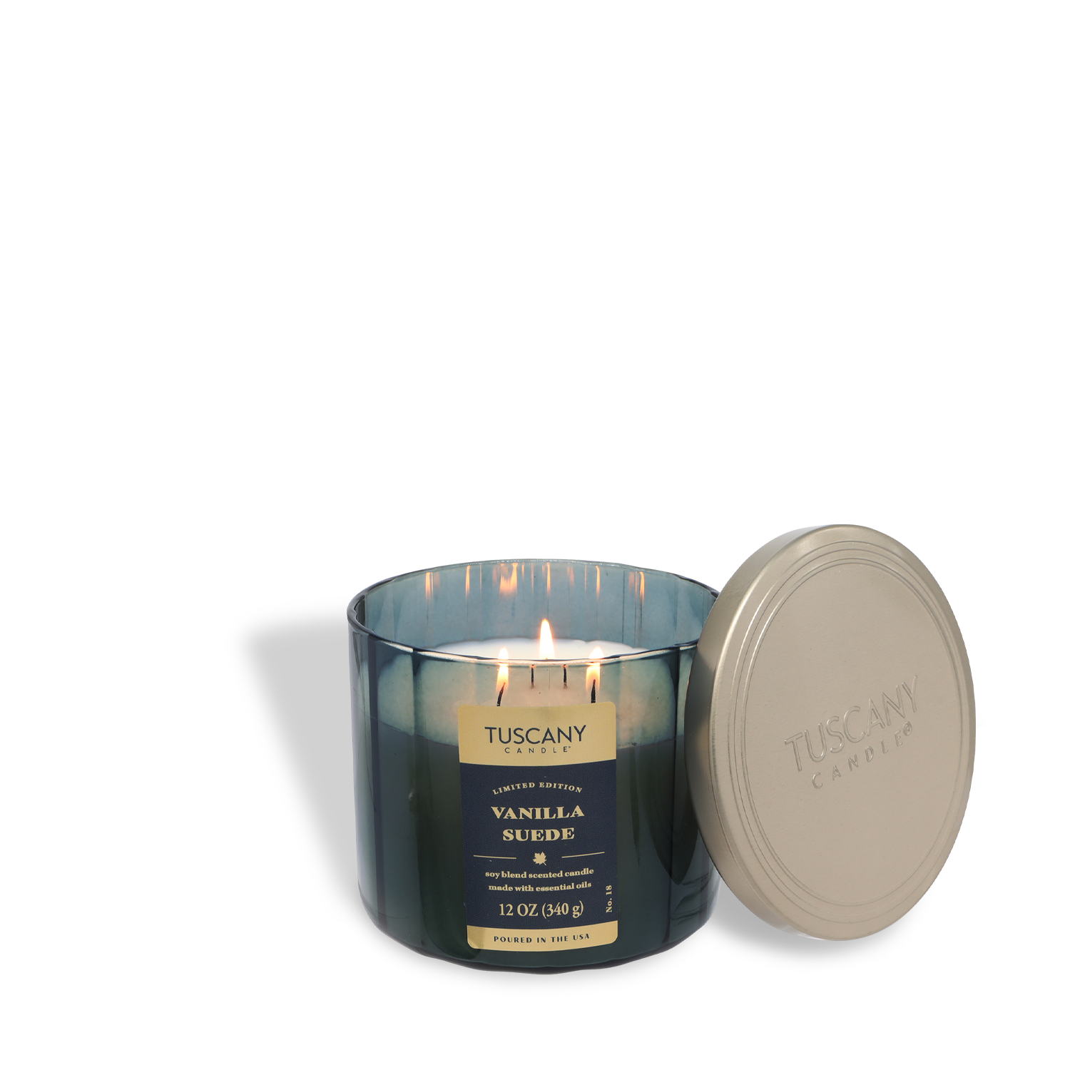 A lit Tuscany Candle® SEASONAL "Vanilla Suede: Sandalwood & Mandarin" fall candle (12 oz) in a blue glass jar, with a silver lid resting beside it.