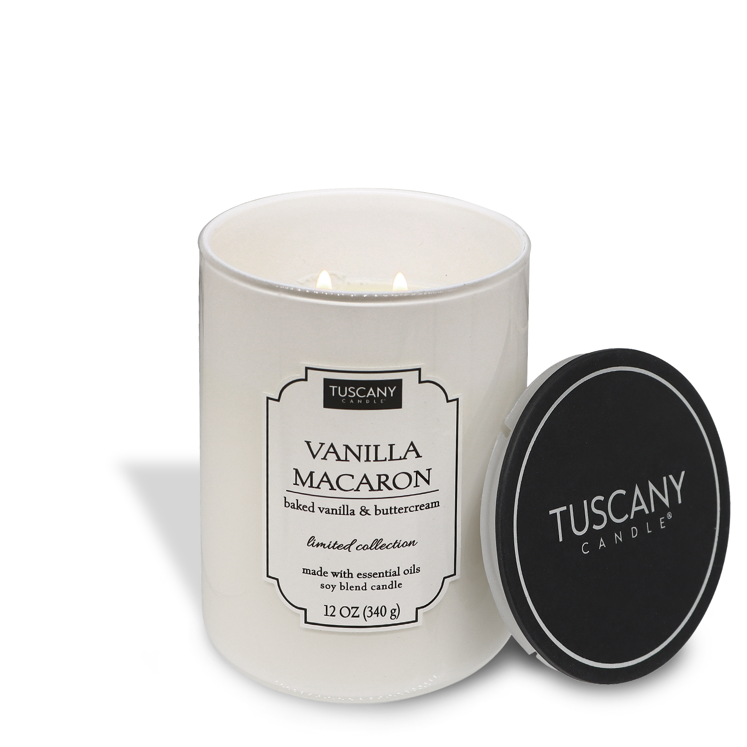 A lit Vanilla Macaron (12 oz) candle from the Colorsplash collection by Tuscany Candle® EVD, with its black lid placed to the right, against a white background.