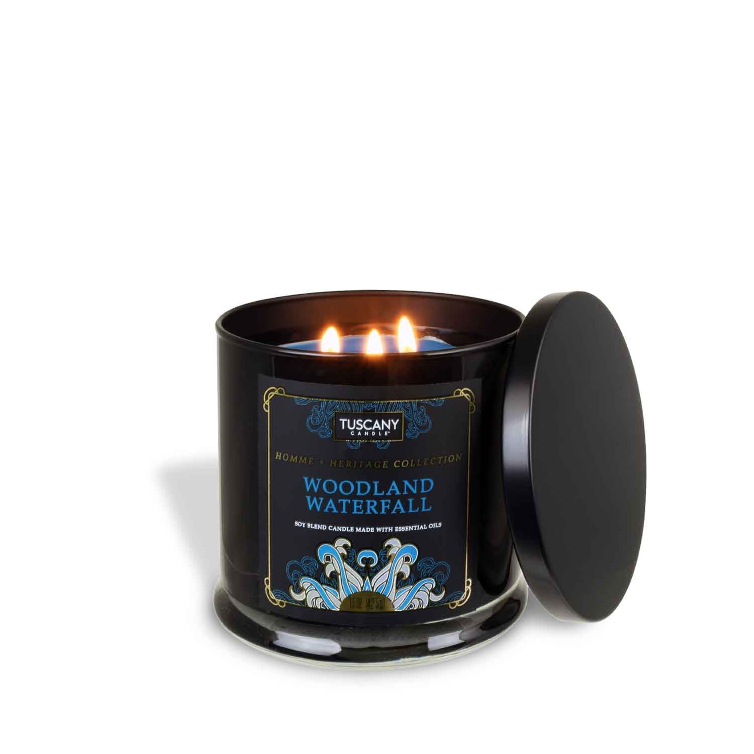 A Woodland Waterfall scented candle in a black tin with fresh ocean air - Homme + Heritage Collection by Tuscany Candle.