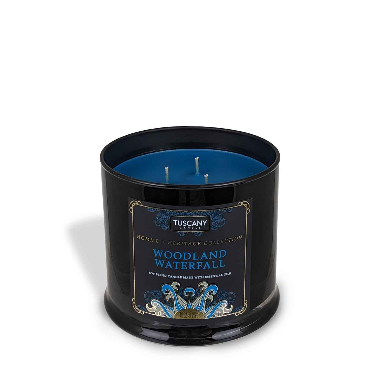 Tuscany Candle's Woodland Waterfall Scented Jar Candle (15 oz) – Homme + Heritage Collection in a black tin with a blue lid, creating a serene ambiance.