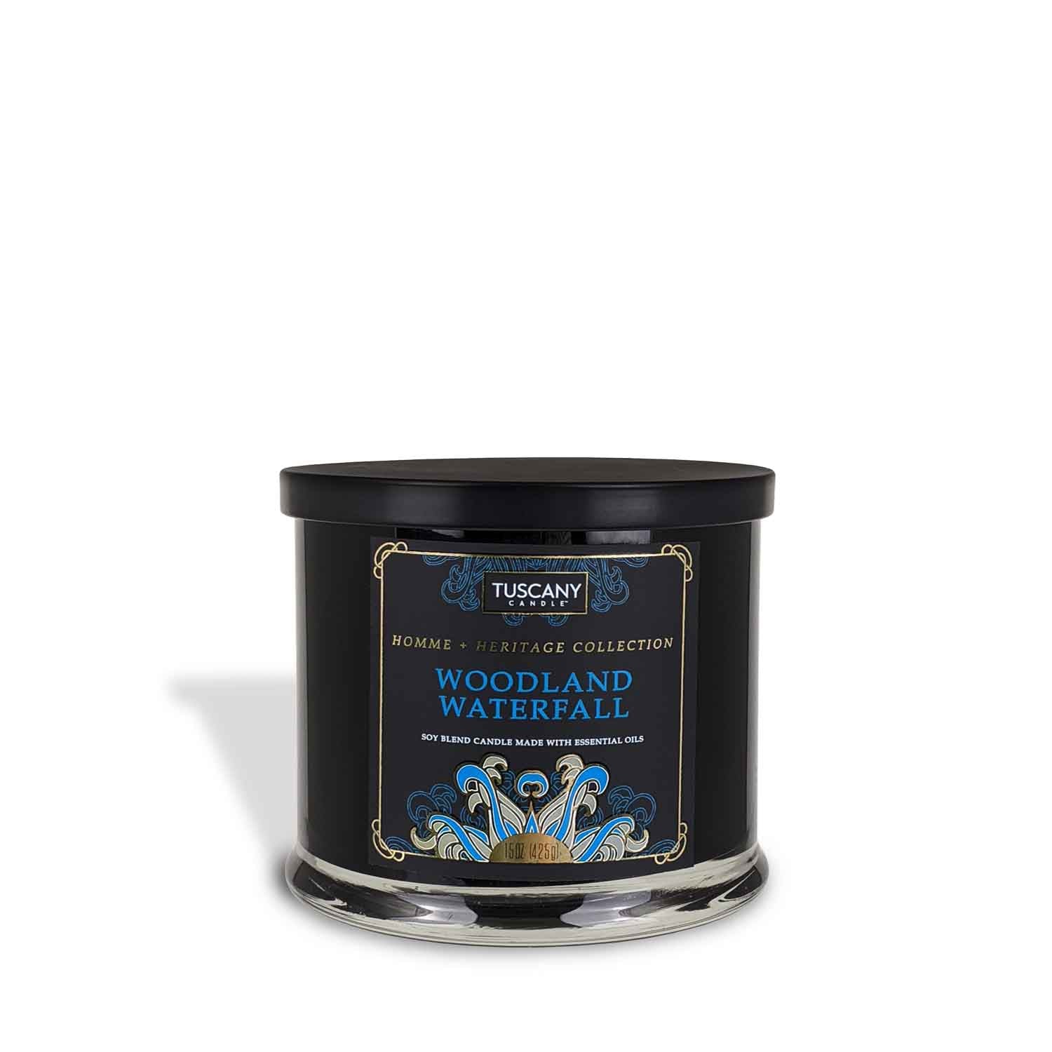 A Woodland Waterfall scented tin candle with a black lid, emanating a serene and fresh ocean air aroma from the Tuscany Candle Homme + Heritage Collection.