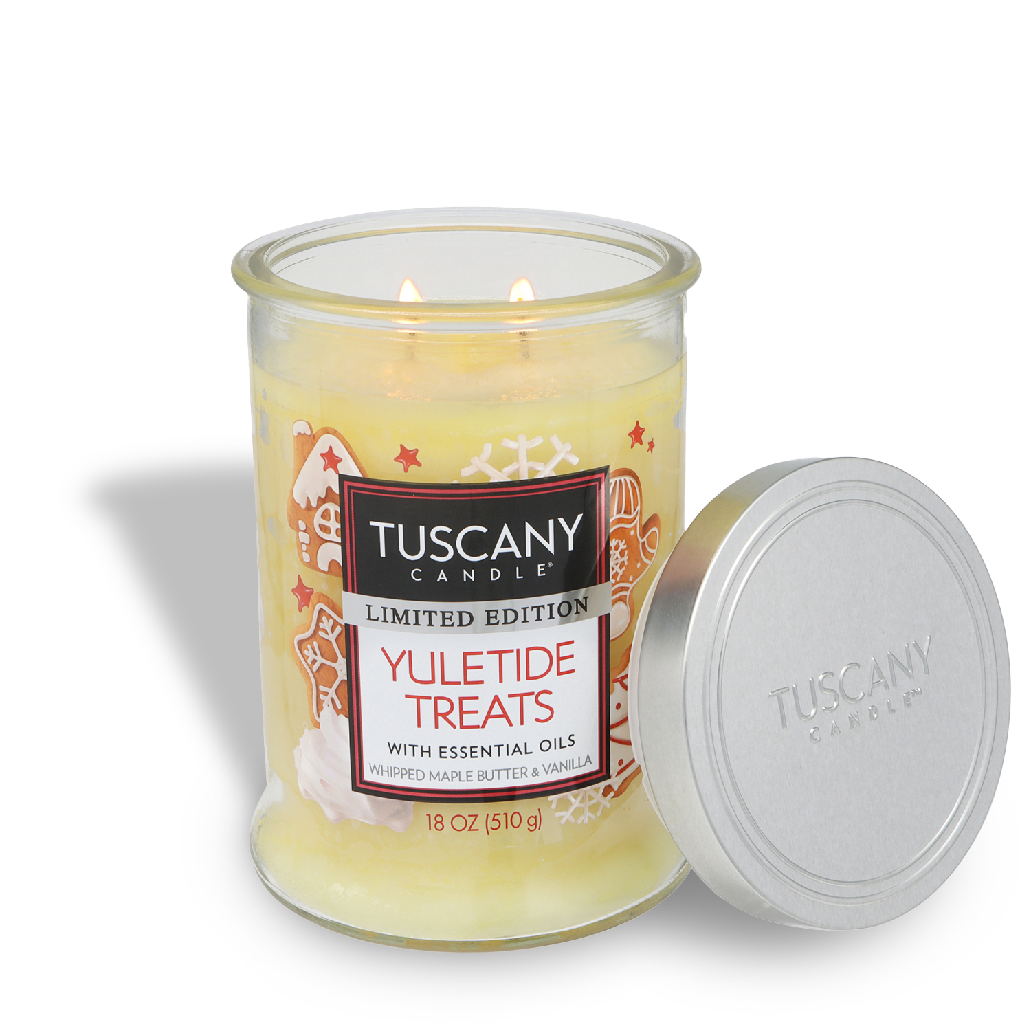 An 18 oz Tuscany Candle® SEASONAL "Yuletide Treats: Whipped Maple & Vanilla Scented Holiday Candle" burns warmly in its glass jar, with the lid placed beside it.
