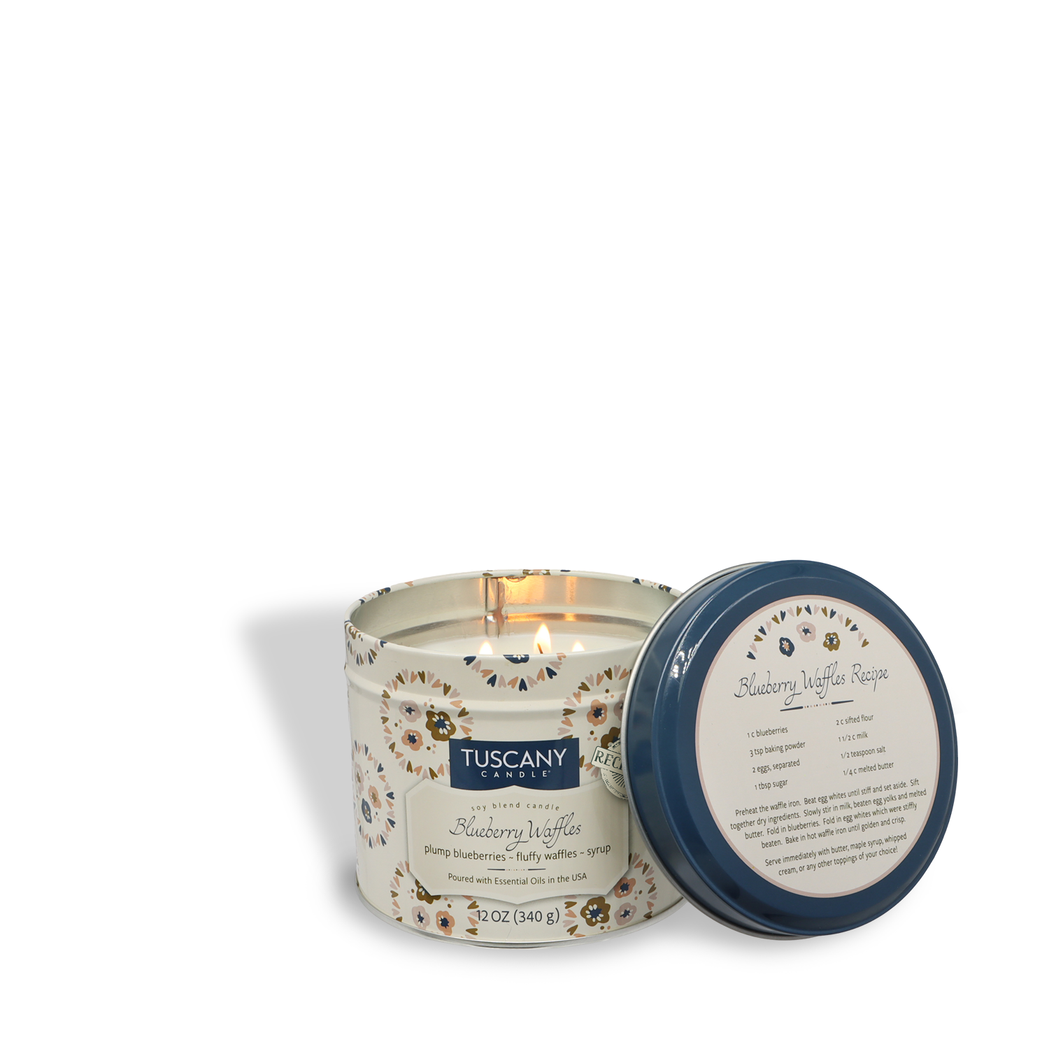 A lit Tuscany Candle® SEASONAL Blueberry Waffles: Maple Syrup & Waffle Scented Fall Candle (12 oz) from the Bakery Tins Collection is displayed in a decorative tin, its lid shown beside it.