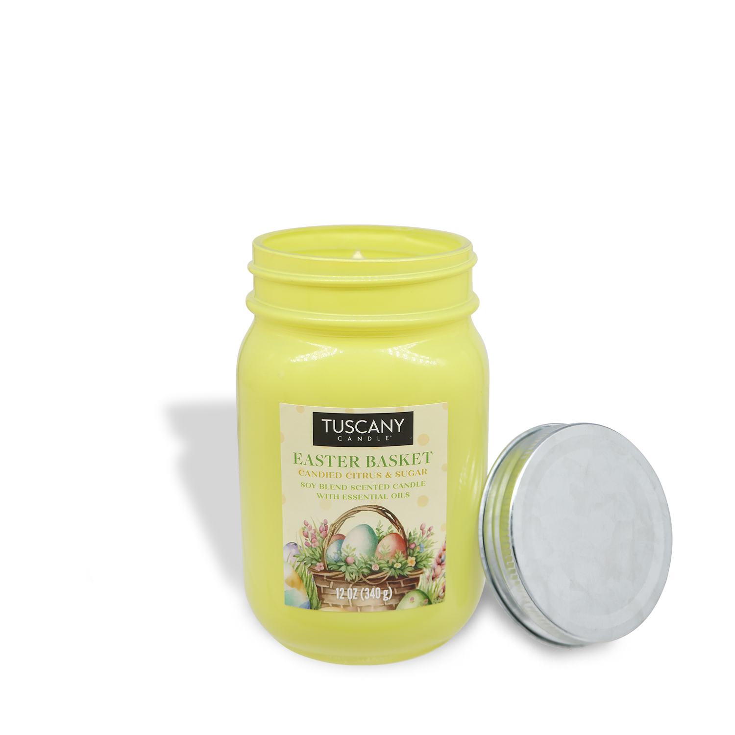 Yellow jar candle "Easter Basket: Candy Scented Easter Candle (12 oz)," by Tuscany Candle® SEASONAL, showcases a floral and egg design with the lid upright beside the jar.