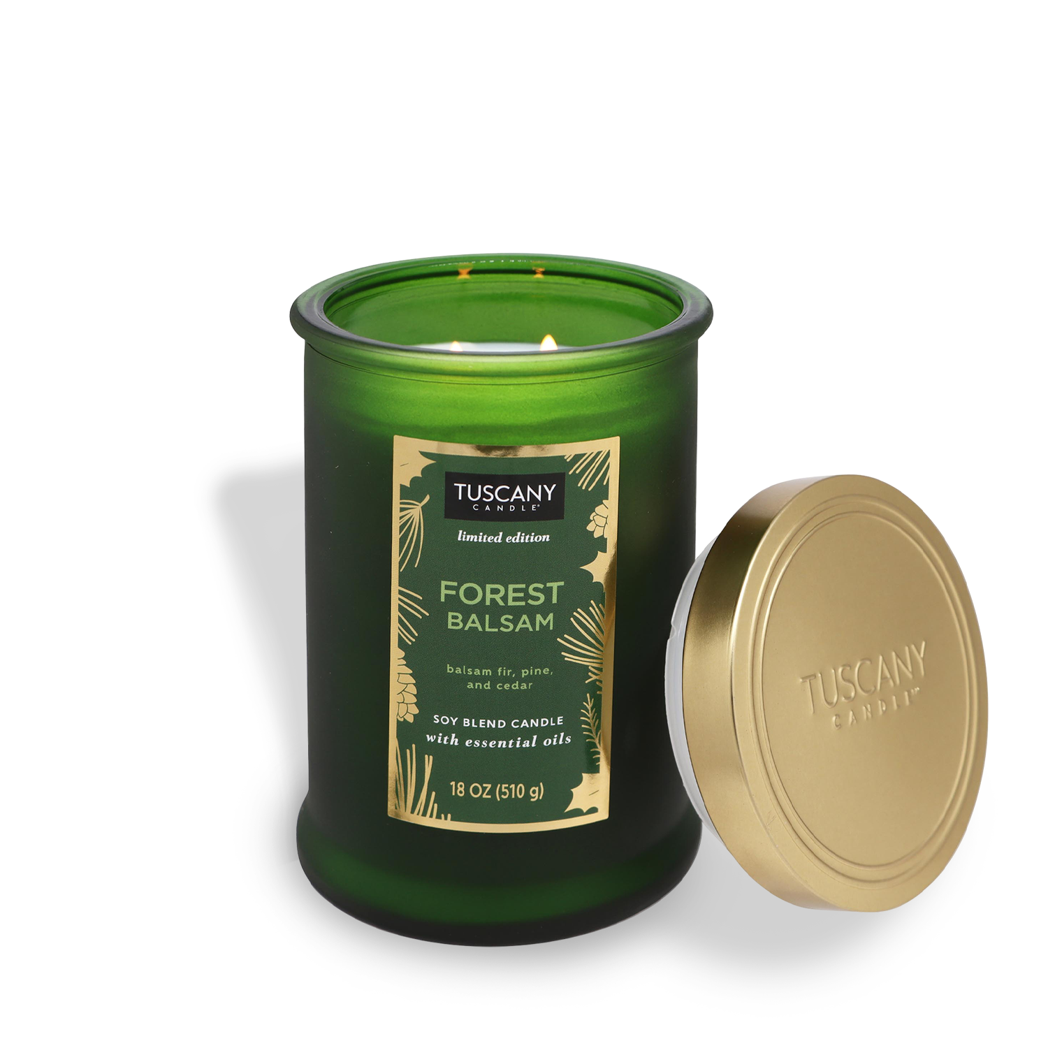 A green glass jar candle from the Winter Reverie Collection, labeled "Forest Balsam" by Tuscany Candle® SEASONAL, is accompanied by its gold lid. This 18 oz (510 g) candle features a soy blend.