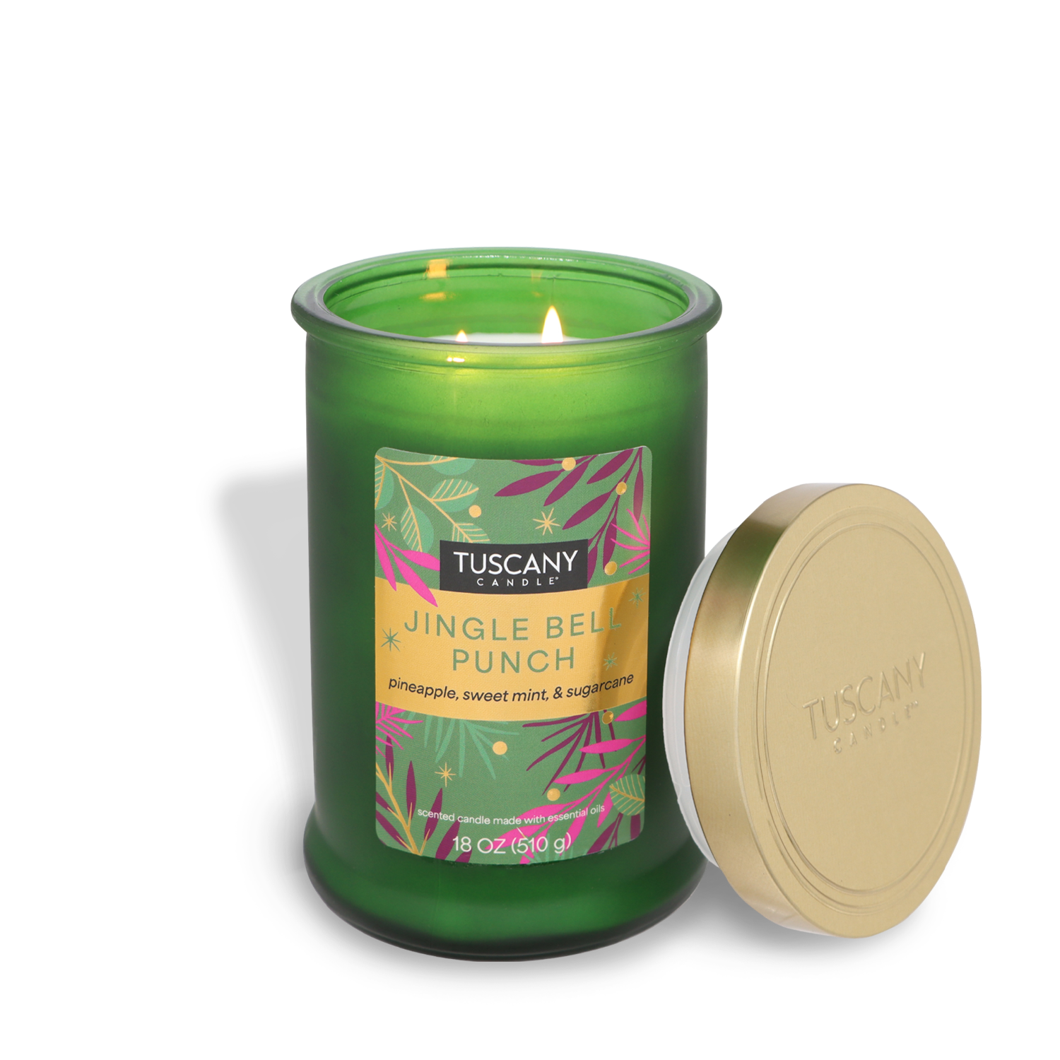 A Tuscany Candle® SEASONAL product named "Jingle Bell Punch" in green, featuring enticing scents of pineapple, sweet mint, and sugarcane, is burning brightly with its gold lid set next to it.