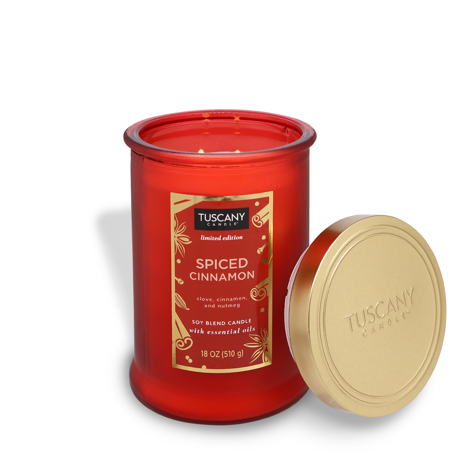 A red jar candle from the Tuscany Candle® SEASONAL brand's Winter Reverie Collection, labeled as "Spiced Cinnamon," with its lid beside it. It contains 18 oz (510 g) of a soy blend infused with essential oils.