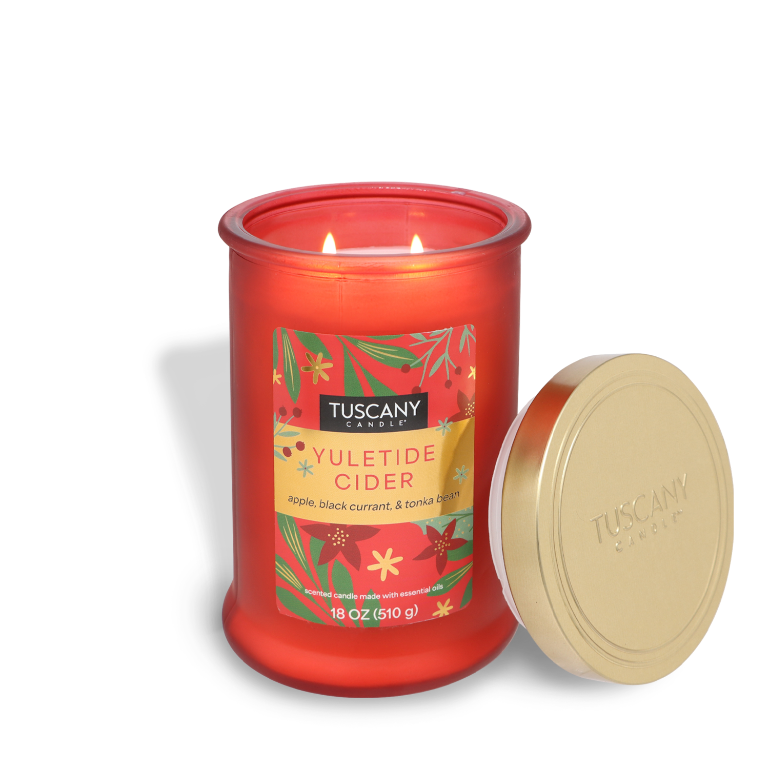 Red candle labeled as the "Yuletide Cider" Scented Jar Candle (18 oz) by Tuscany Candle® SEASONAL, featuring the enticing scents of apple, black currant, and tonka bean. The lid is placed beside the candle.