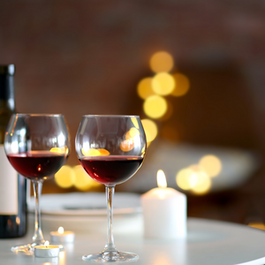 A photo of two romantic glasses of cabernet wine poured in a room filled with scented candles. This photo evokes our "Vineyard Retreat" scented candle