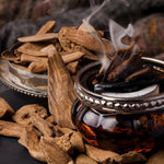 Load image into Gallery viewer, A still life photo of oud and incense, two of the prominent fragrance notes found in the &quot;Smoked Sandalwood&quot; scented candle from Tuscany Candle&#39;s &quot;Homme &amp; Heritage&quot; collection
